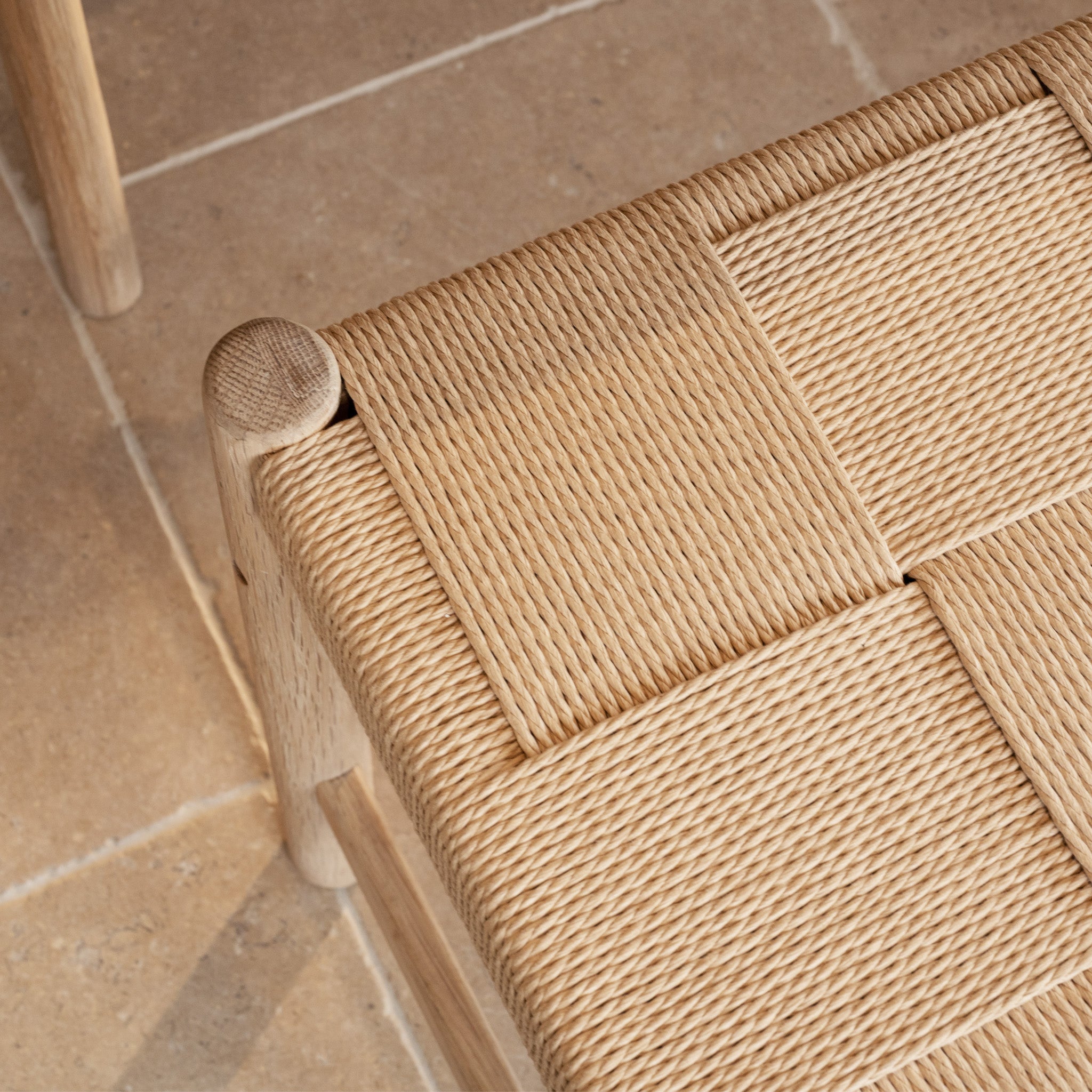 A close-up of the Marlow Set of 2 Woven Dining Chair in Light Oak, featuring seats crafted from Danish cord for a timeless woven look.