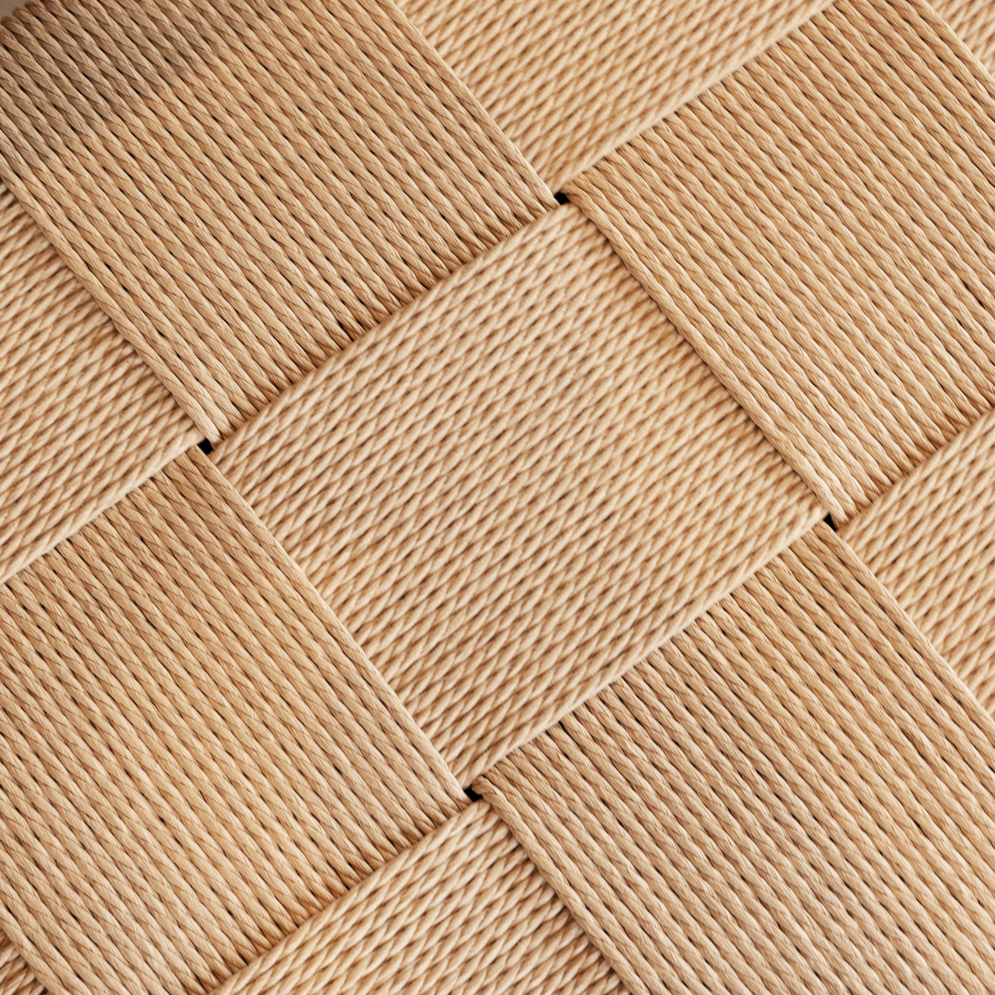 Close-up of the woven beige basket pattern with crisscrossing textured strips, seen on the Marlow Set of 2 Woven Dining Chair in Light Oak.