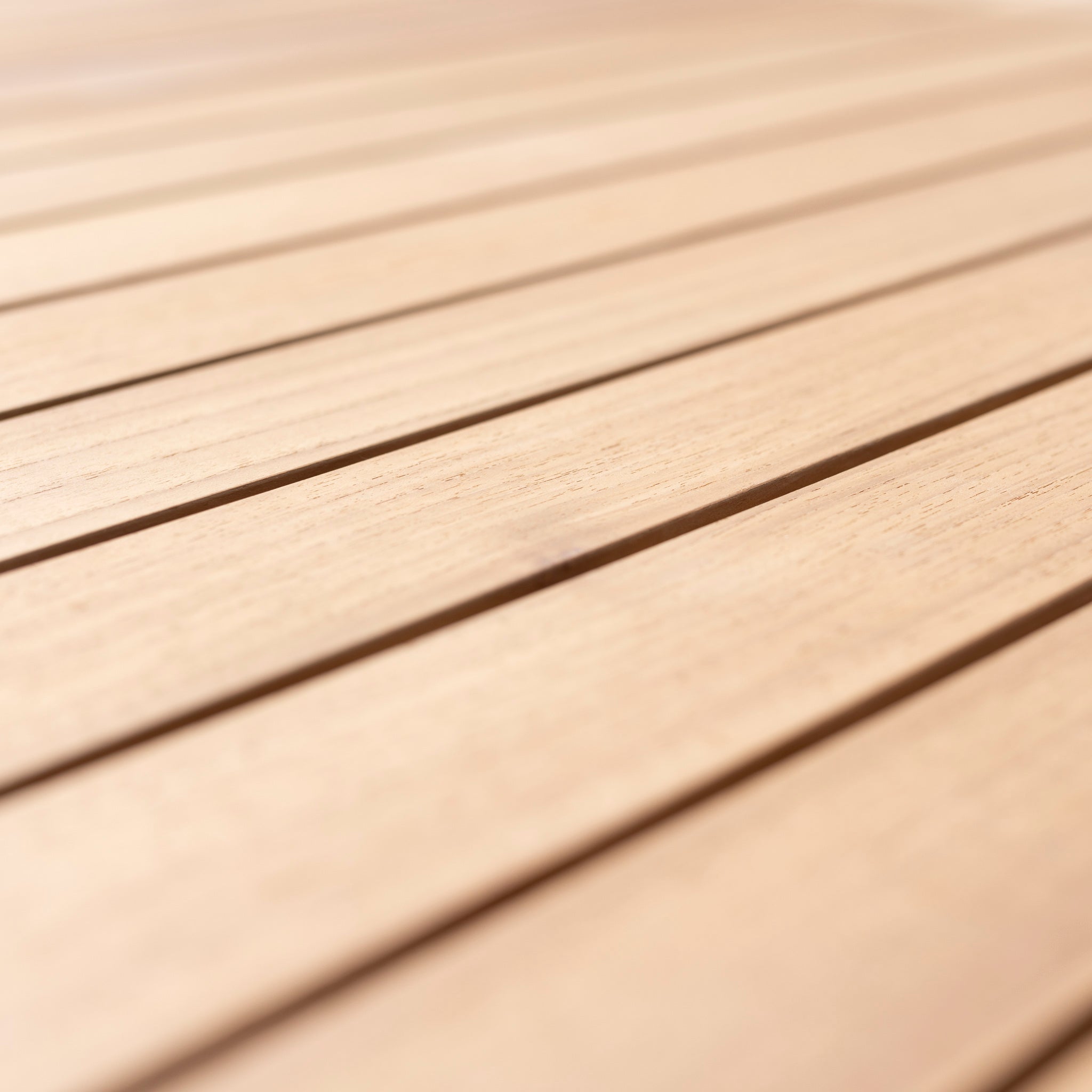 Close-up view of light-colored wooden planks with even spacing, creating a smooth and uniform surface, perfect for complementing your Monterrey 8 Seat Rope Rectangular Teak Firepit Dining Set in Grey from Harbour Lifestyle.