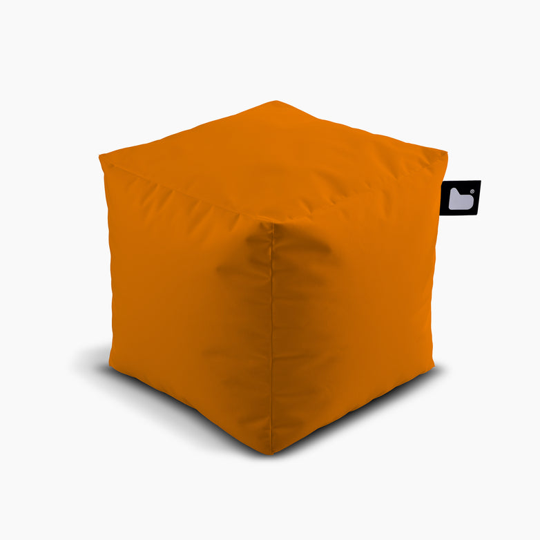 The Outdoor B-Box in Orange is a cube-shaped ottoman that comes with a small black tag featuring a white logo on one corner. Set against a white background, this waterproof piece is perfect for extreme lounging, ensuring both style and durability.