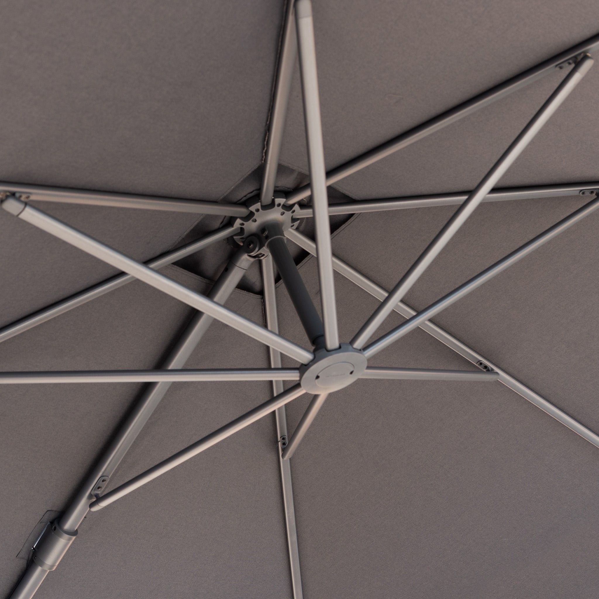 Close-up view of the underside of the Nexus T2 Premium 3m Square Cantilever Parasol in Black with a 90kg granite base, highlighting its sturdy metal frame and smooth 360-degree rotation mechanism.