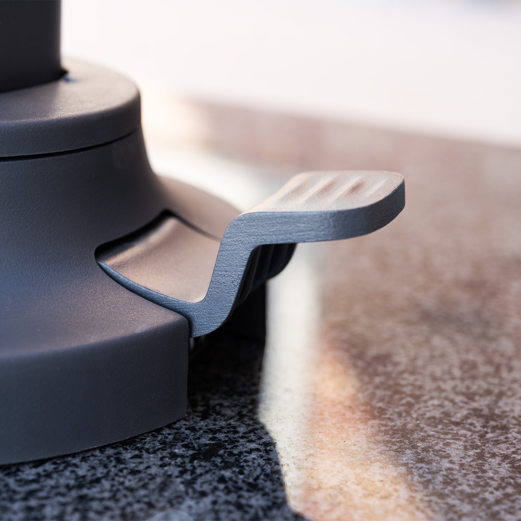 Close-up of the Nexus T2 Premium 3m Square Cantilever Parasol in Manhattan Grey with 90kg Granite Base, featuring a gray lever on a round metal base for smooth 360-degree rotation—ideal for easy parasol adjustment.