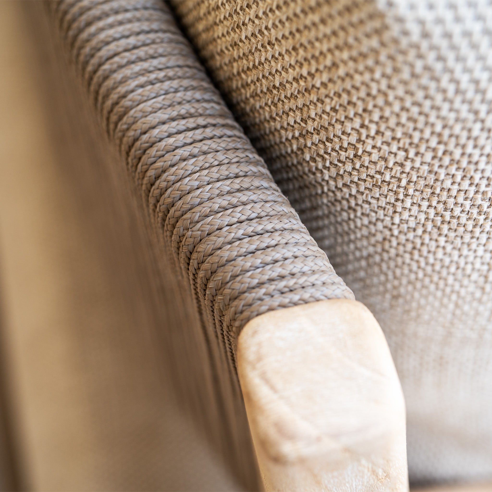 Close-up of a woven armrest from the Noah Corner Sofa Set with Armchair in Volga Grey, featuring light wood and textured upholstery—a perfect pairing with rustic teak outdoor furniture.