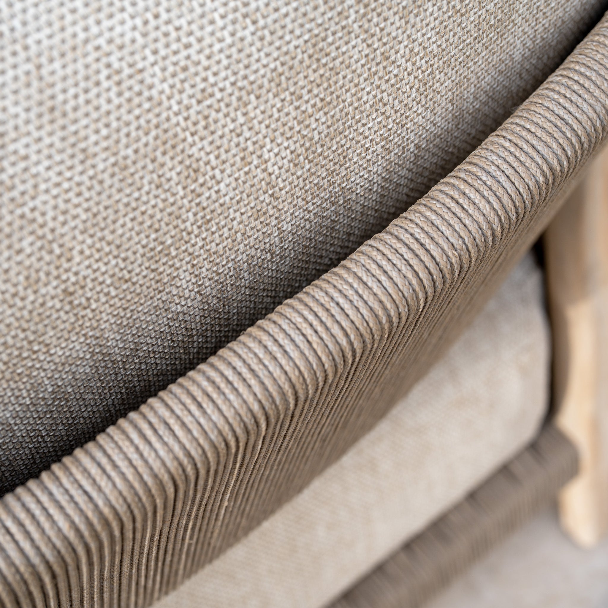 Close-up of textured Volga Grey fabric and ribbed brown trim on the Noah Corner Sofa Set with Armchair, part of the rustic teak outdoor collection.