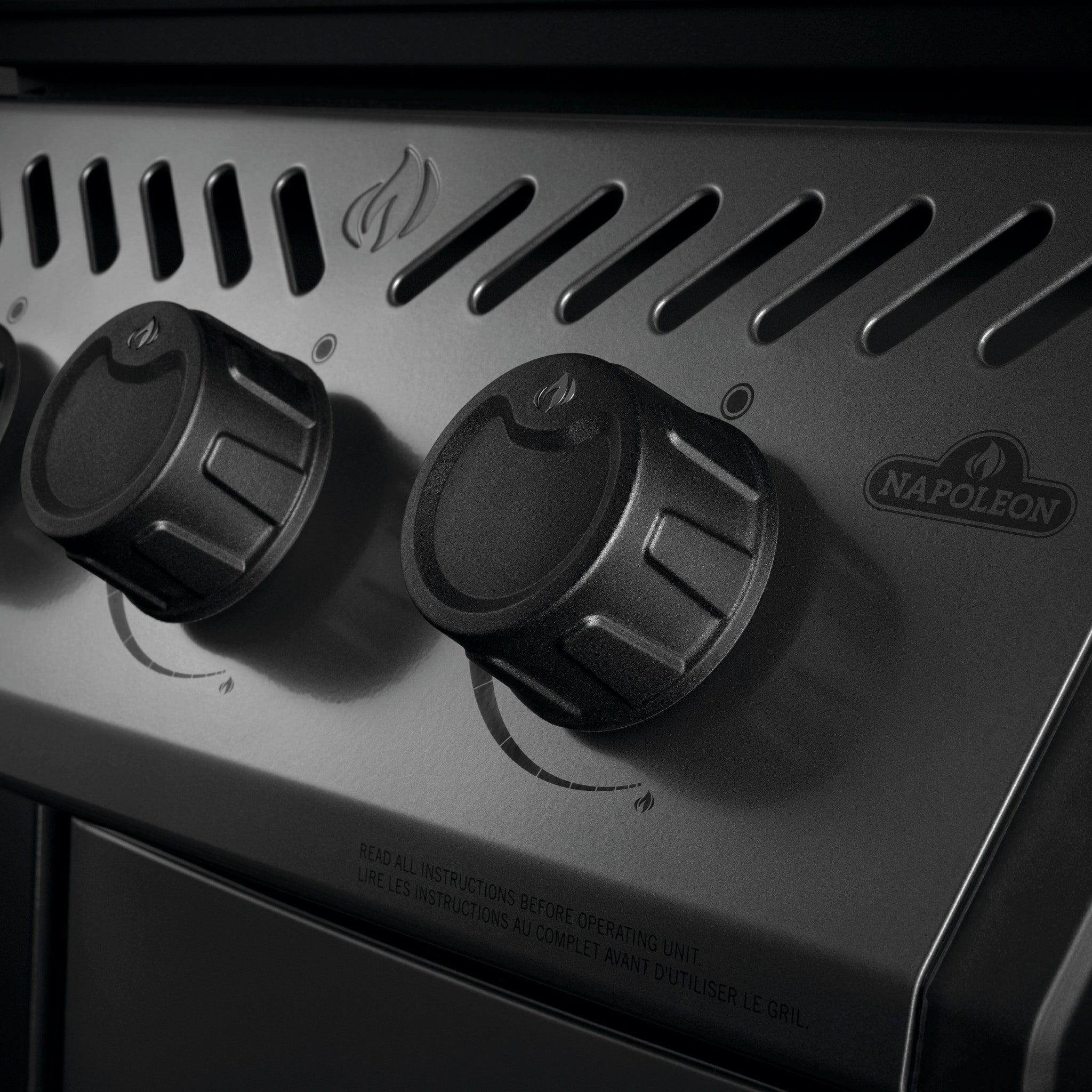 Close-up of black control knobs with flame icon on a Napoleon Freestyle 365 Gas Barbecue, featuring cast iron cooking grids.