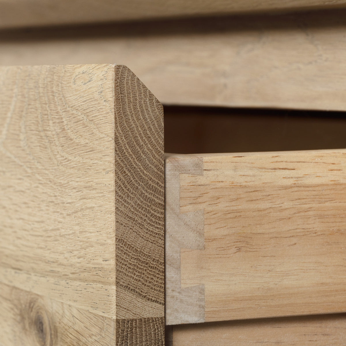 Close-up of an open drawer on the Oslo 2 Drawer Console Table in Light Oak, highlighting dovetail joints at the corner and a smooth wood grain finish.