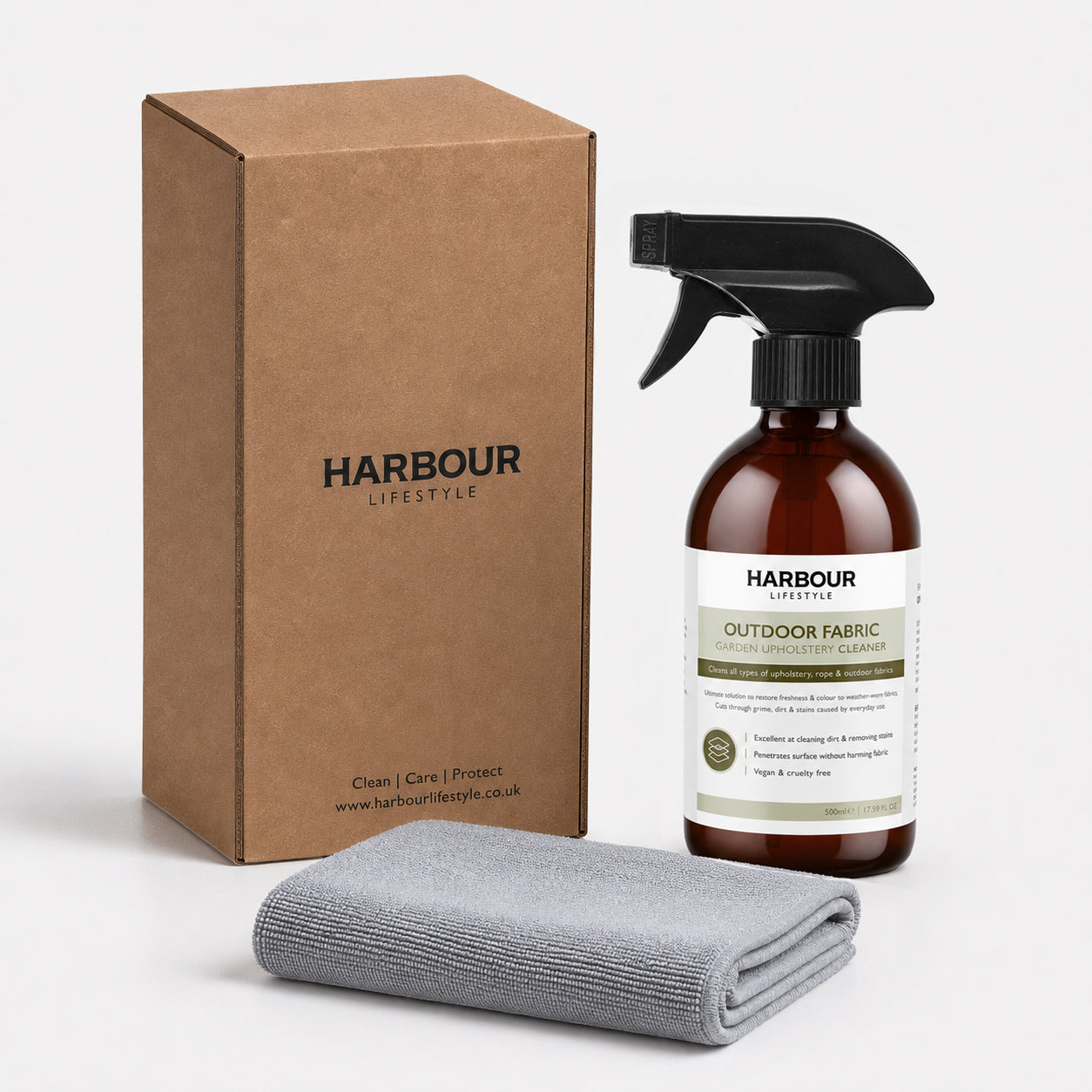 Brown box, spray bottle labeled “Outdoor Furniture Cushion, Rope and Upholstery Cleaner,” and a folded gray cloth on a white background—ideal for anyone seeking a powerful outdoor furniture cleaner or dependable Garden Upholstery Cleaner for refreshed, spotless results.