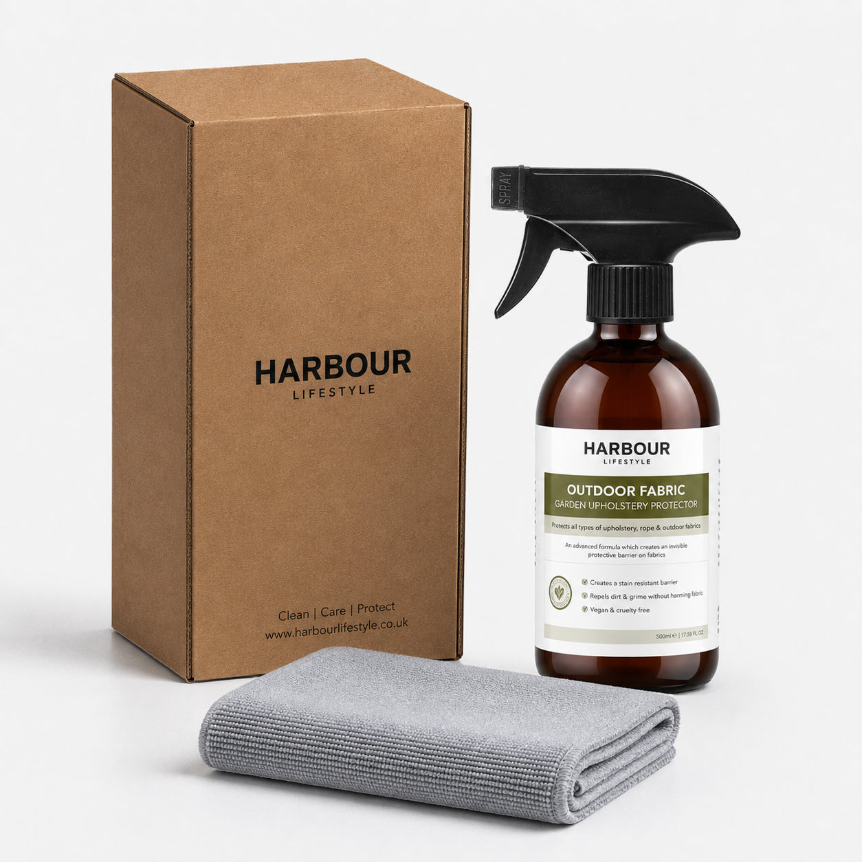 Brown box, spray bottle labeled “Outdoor Furniture Cushion, Rope and Upholstery Protector,” and folded gray cloth on white background—an essential waterproof spray that keeps your cushions and outdoor fabrics protected and fresh.
