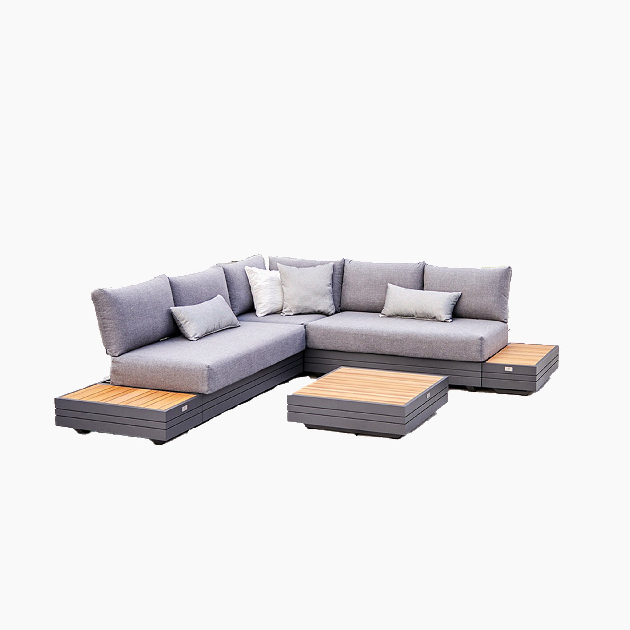 The Panama Luxury Outdoor Corner Group Set in Washed Grey includes a gray L-shaped sofa with cushions, a wooden platform base, integrated wooden side tables, and a separate low table. This modular sofa set is crafted from sustainable teak, epitomizing luxury outdoor furniture.