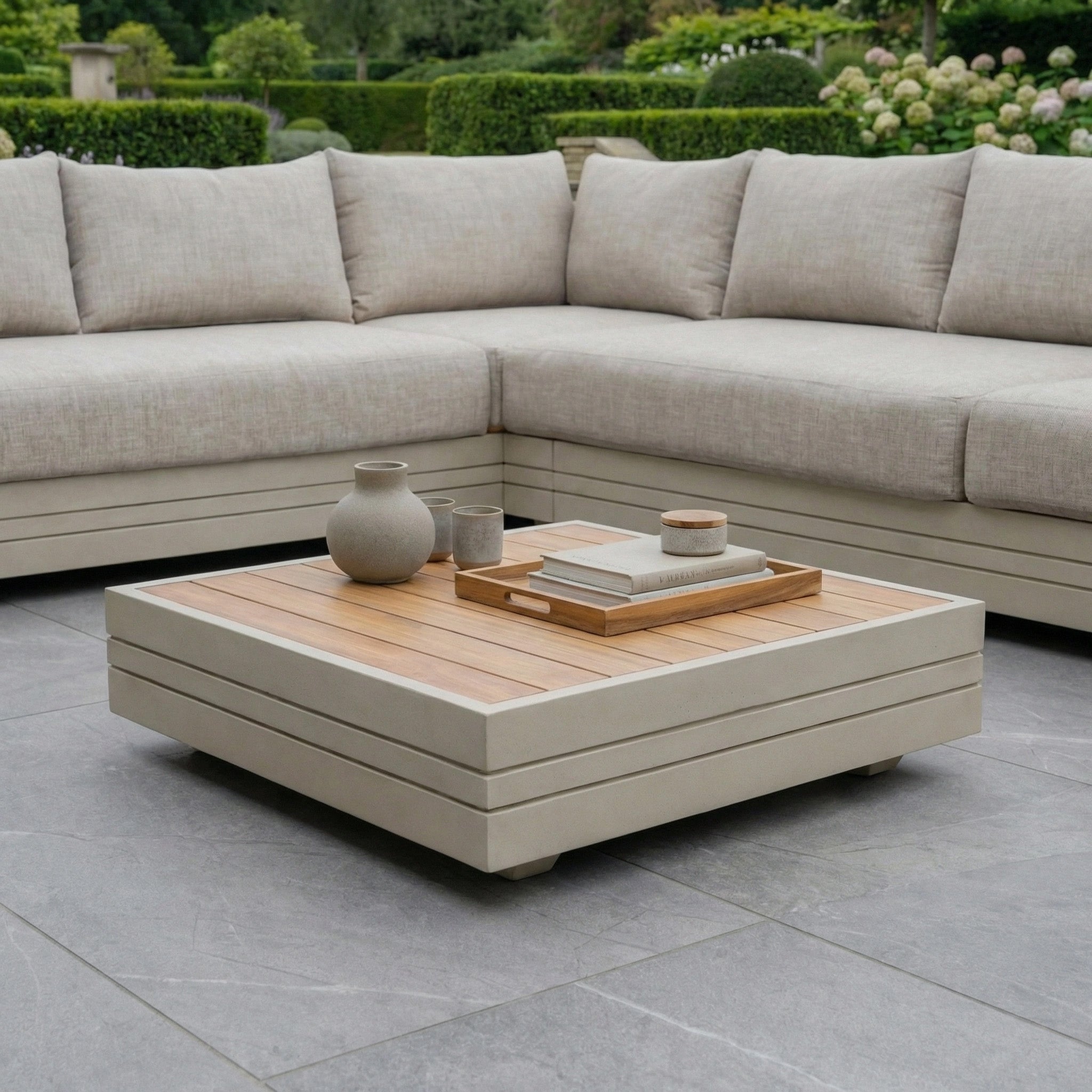 Modern patio with the Panama Luxury Outdoor L-Shape Corner Group Set in Latte, paired with sustainable teak garden furniture holding ceramic vases and a tray.