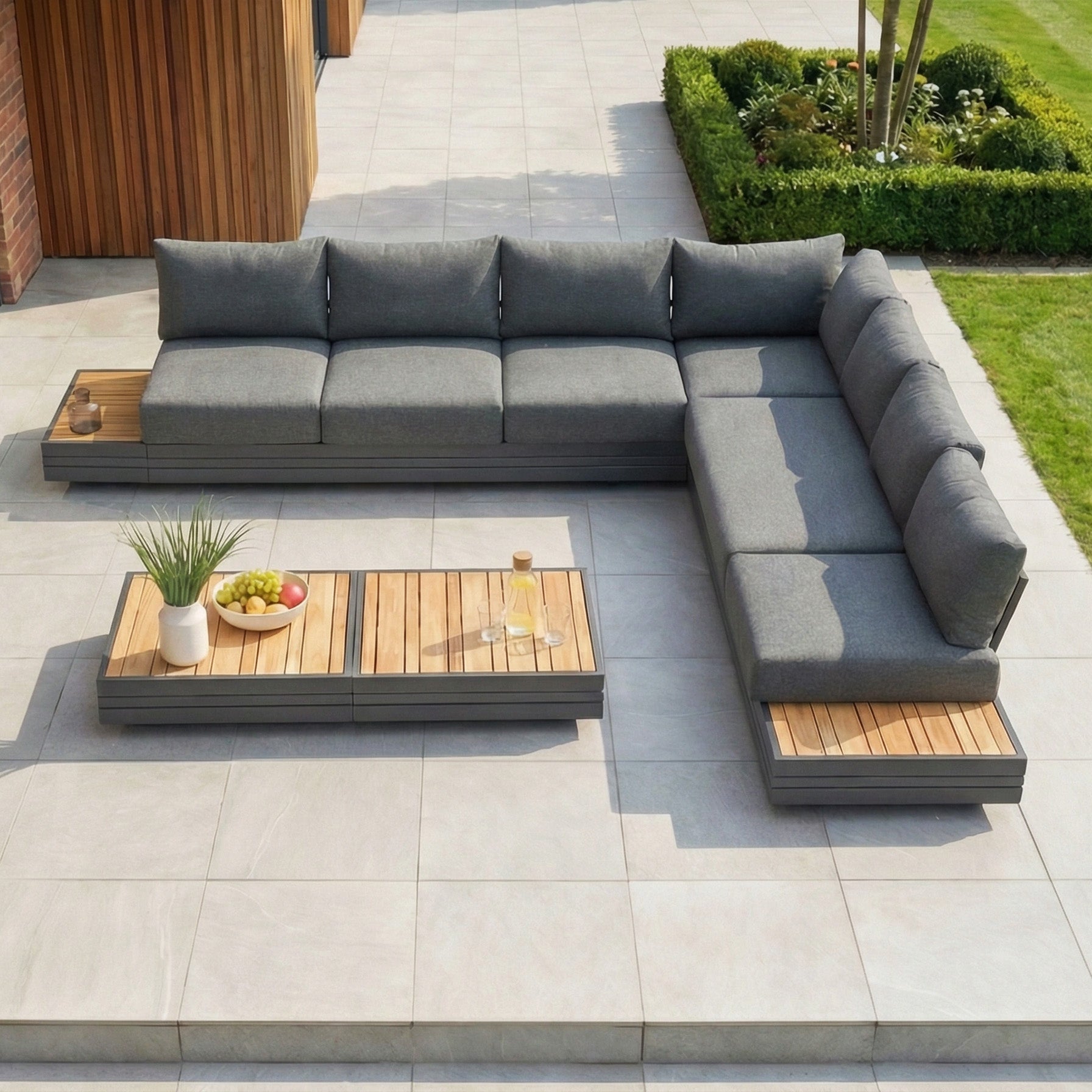Charcoal Panama Luxury Outdoor Large Corner Group Set with wooden accents and matching coffee table on a tiled patio by the garden—perfect for elegant, modular outdoor living.