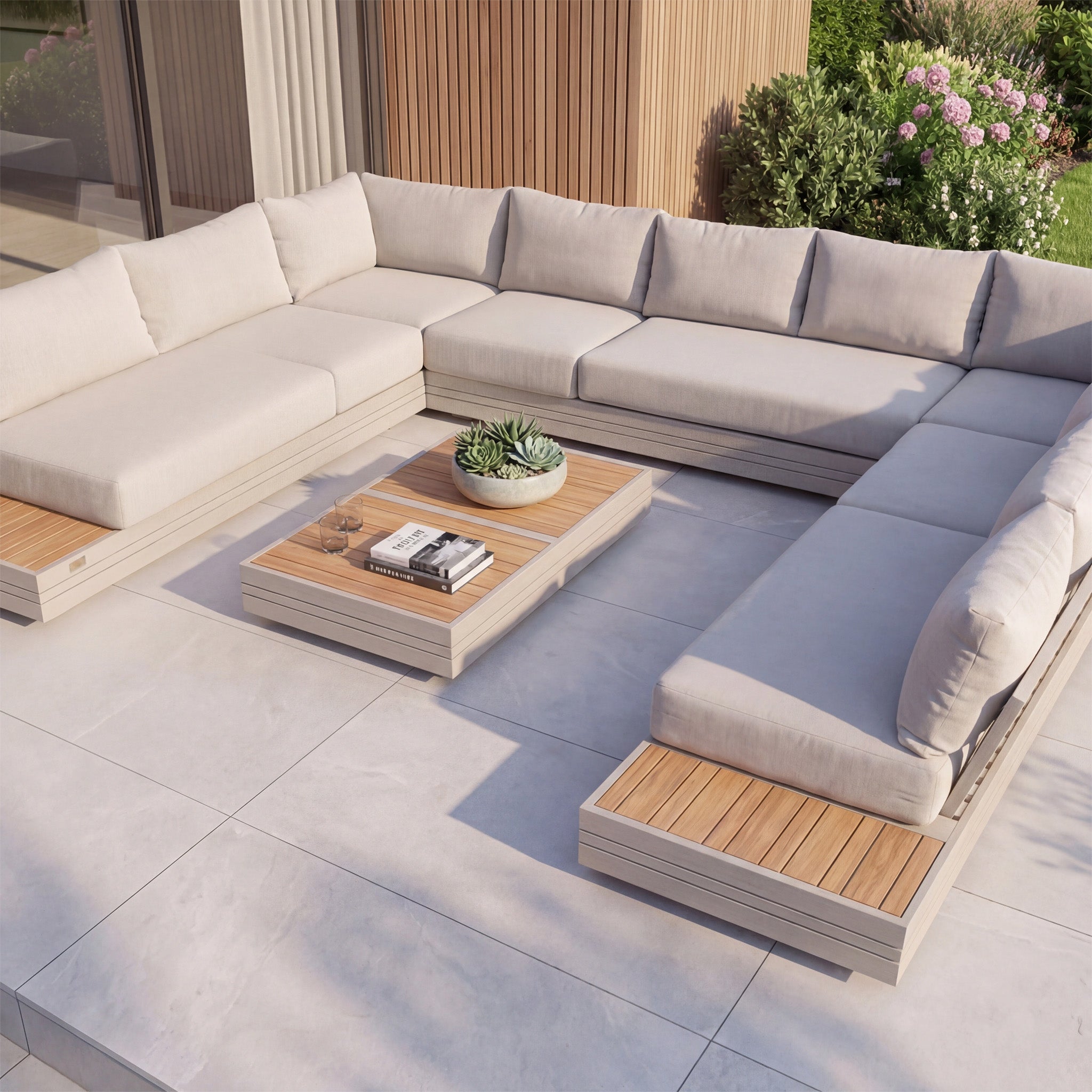 Modern outdoor patio with the Panama Luxury Outdoor Large U-Shape Corner Sofa Set in Latte, a teak coffee table, and potted plant, all surrounded by lush greenery.