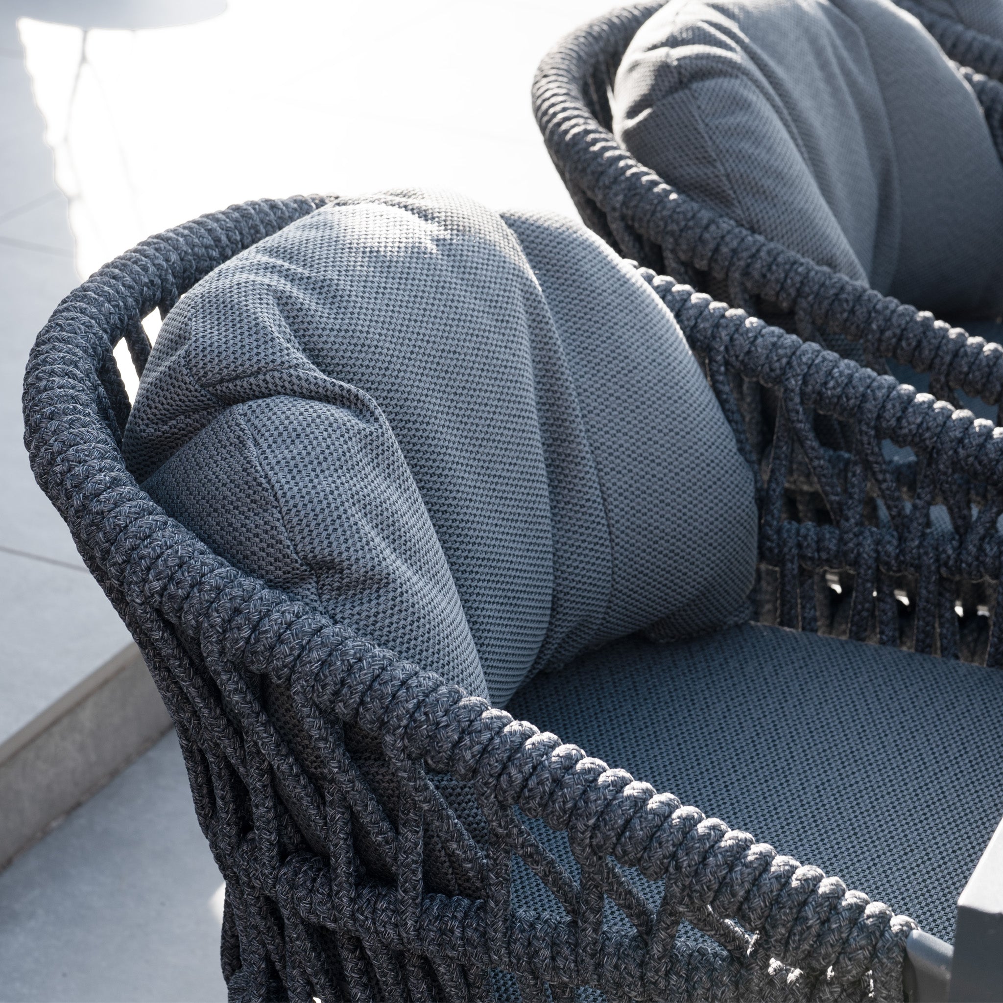 Close-up of a modern outdoor dining chair with thick woven frame and textured gray cushions, perfect for pairing with the Pello 8 Seat Dining Set with Albatross Extending Table in Grey.
