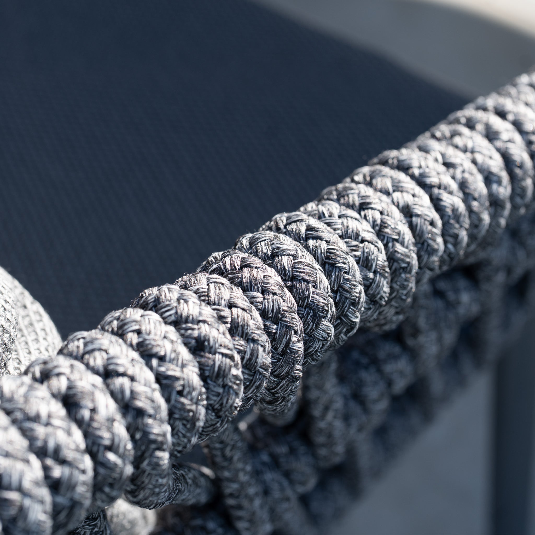 Close-up of the woven grey rope detail on the Pello 8 Seat Dining Set with Albatross Extending Table in Grey, shown with a blurred background.