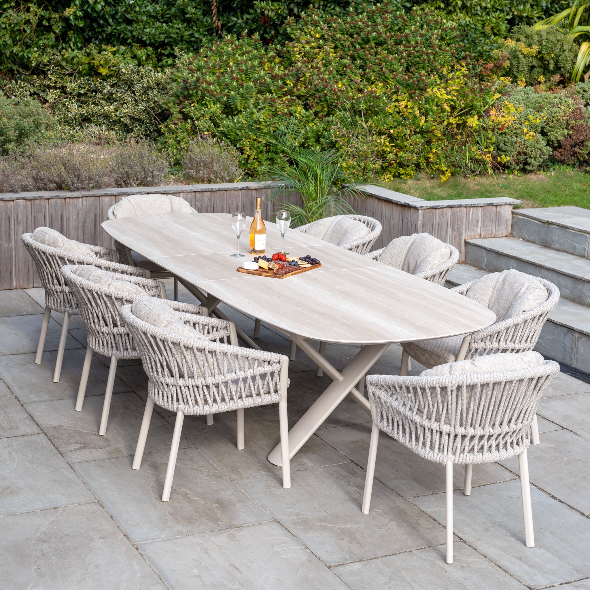 The Pello 8 Seat Oval Dining Set with Albatross Extending Table in Fawn features a wooden table and eight wicker chairs, offering a stylish and durable choice for outdoor dining on your patio.