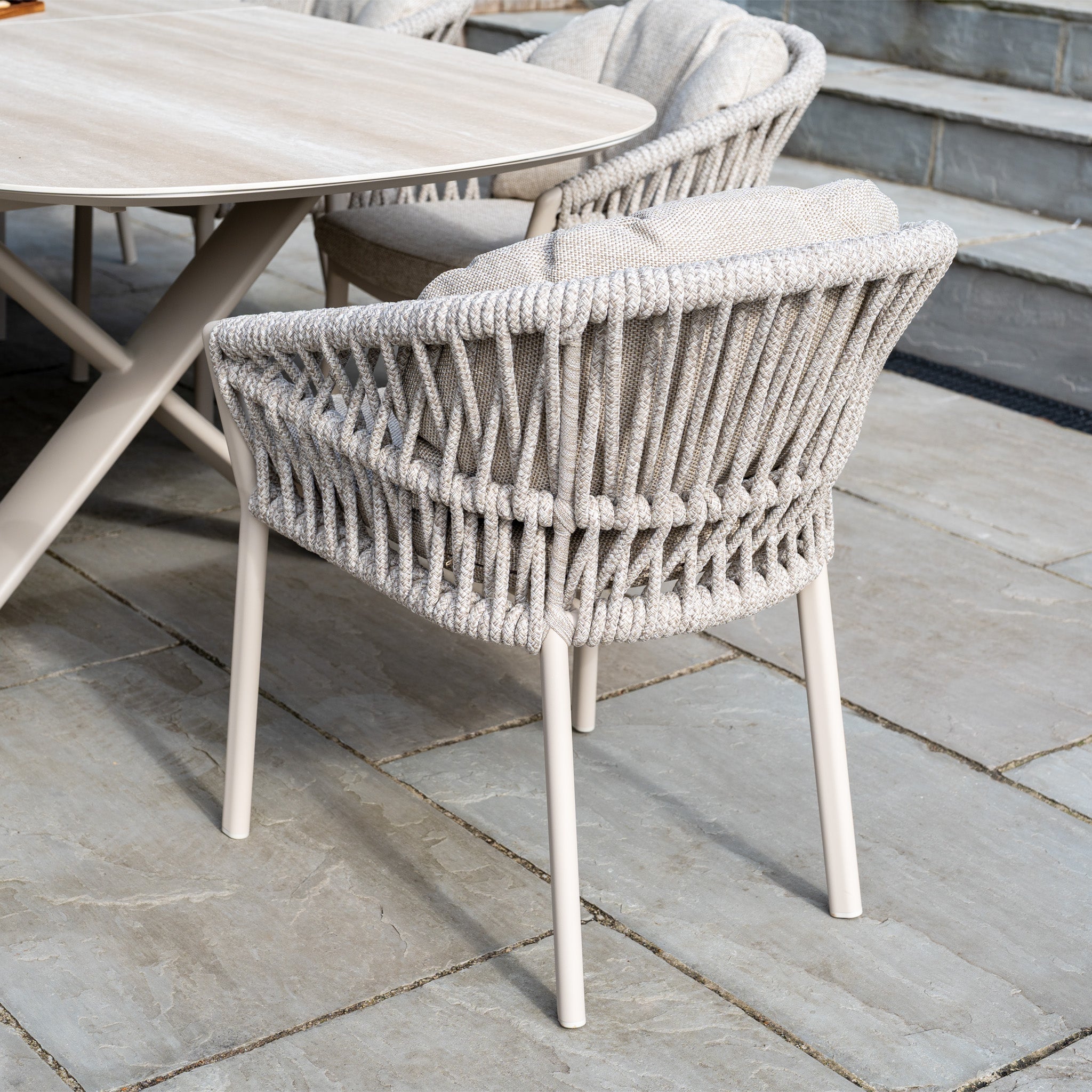 The Pello 8 Seat Oval Dining Set with Albatross Extending Table in Fawn features beige rope-woven chairs and a light wood table, creating a stylish and durable garden furniture set for your patio.