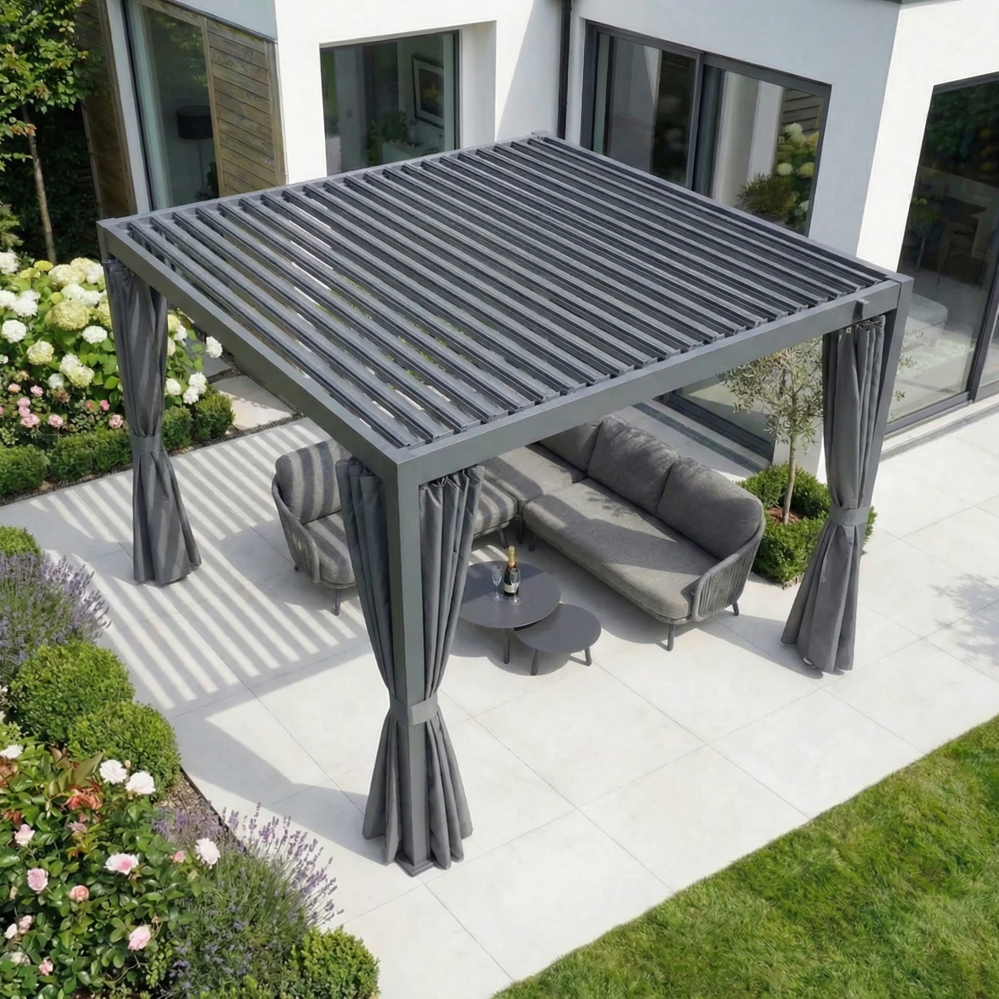 Enhance your patio with PergoSTET Side Curtains for Lite and Lite Neo 3m x 3m Square Pergola in Grey—stylish, weather-resistant outdoor curtains that add comfort and privacy to your outdoor seating beside a white house and garden.