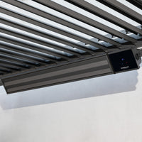 The PergoSTET 2400W Wifi & Bluetooth Heater in Black is ceiling-mounted on metal slats against a white wall, providing efficient and stylish outdoor heating.