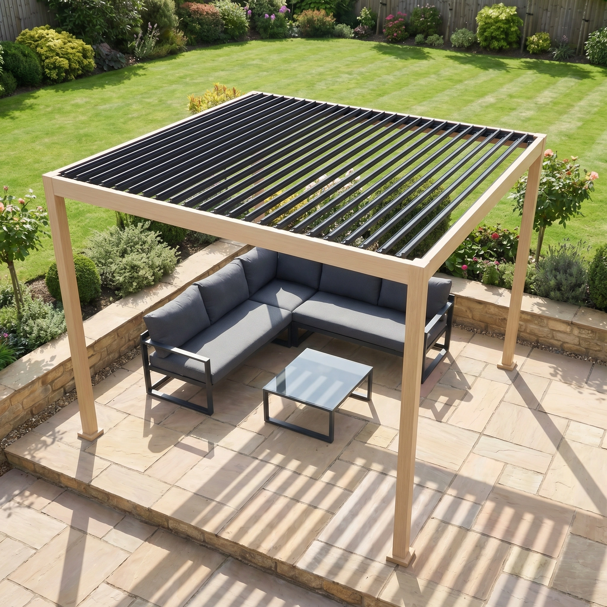 The PergoSTET Lite 2.4m x 3m Metal Rectangular Pergola with Wood Effect, combined with a sectional sofa and table on a stone patio, adds a contemporary touch to this landscaped garden.