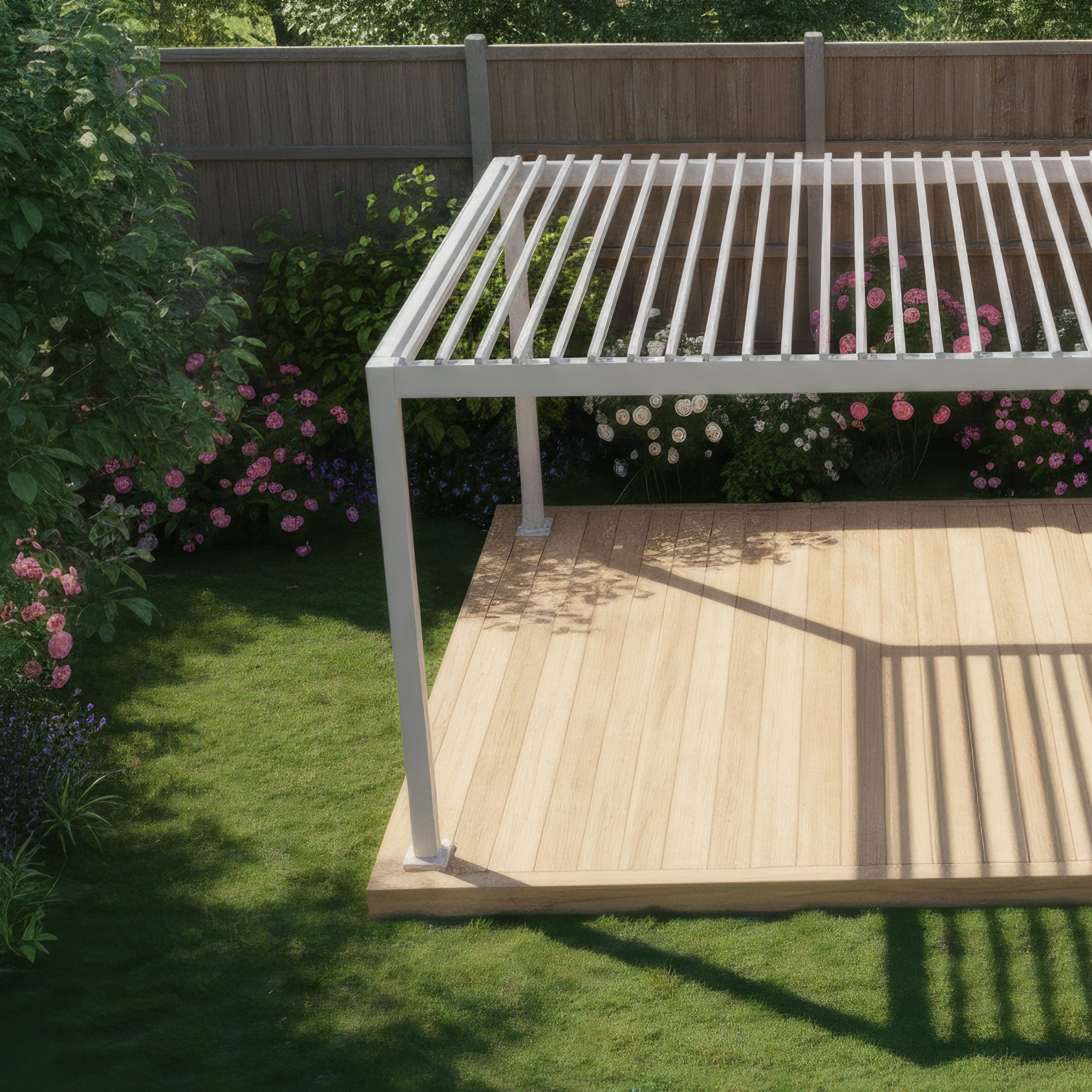 The PergoSTET Lite 2.4m x 3m Metal Rectangular Pergola in Latte stands on a wooden deck in a sunny, flower-filled backyard, offering versatile outdoor shelter with its modern tilting louvres.