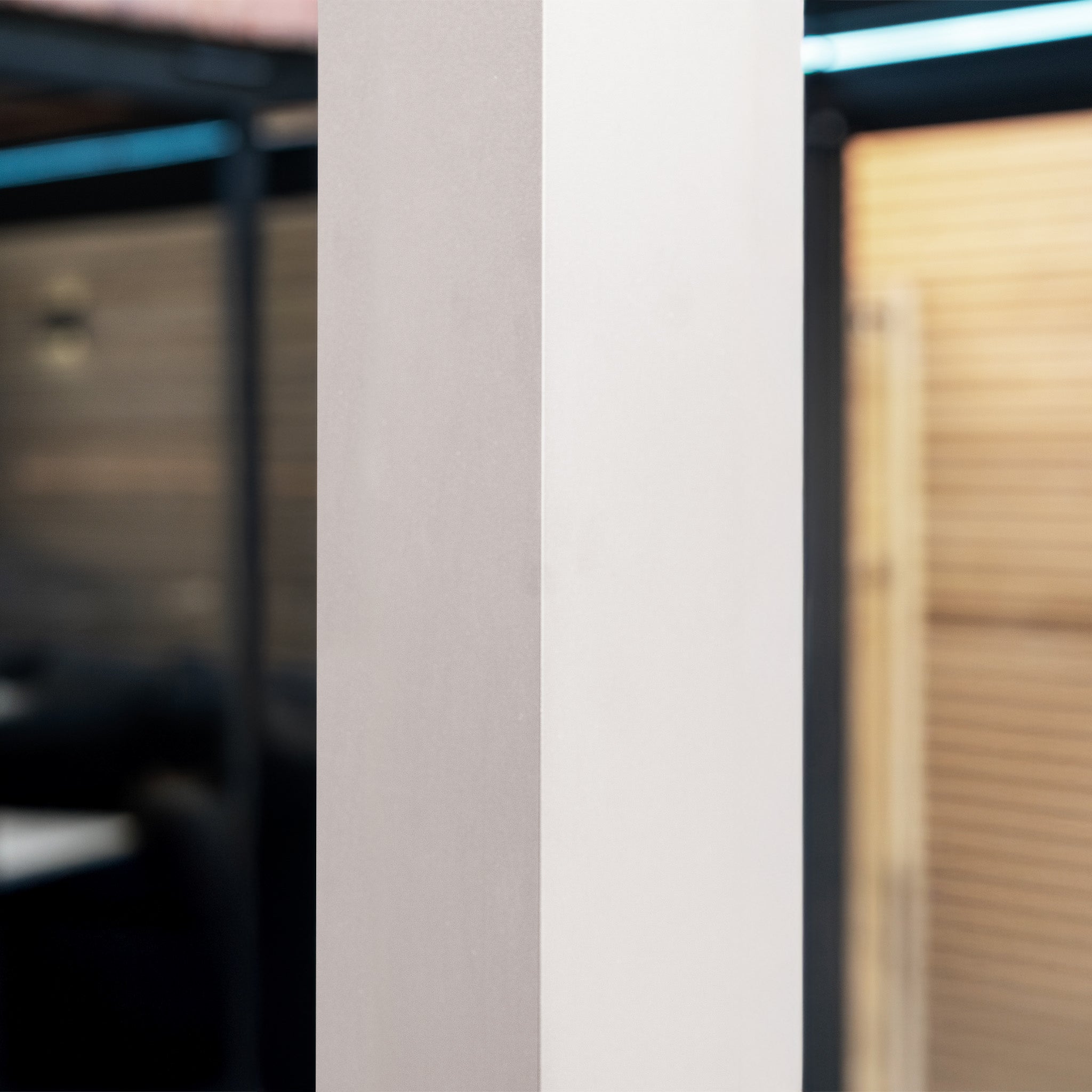 A close-up of a two-toned vertical pillar from the PergoSTET Lite 3m x 4m Metal Rectangular Pergola in Latte, set against a blurred outdoor background.