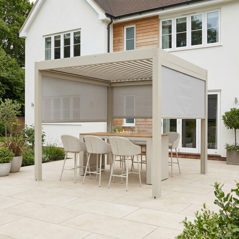 The PergoSTET Plus 3m x 3m Square Pergola with 3 Manual Side Blinds and LED Lighting in Latte covers an outdoor dining set on a tiled patio beside a white house.