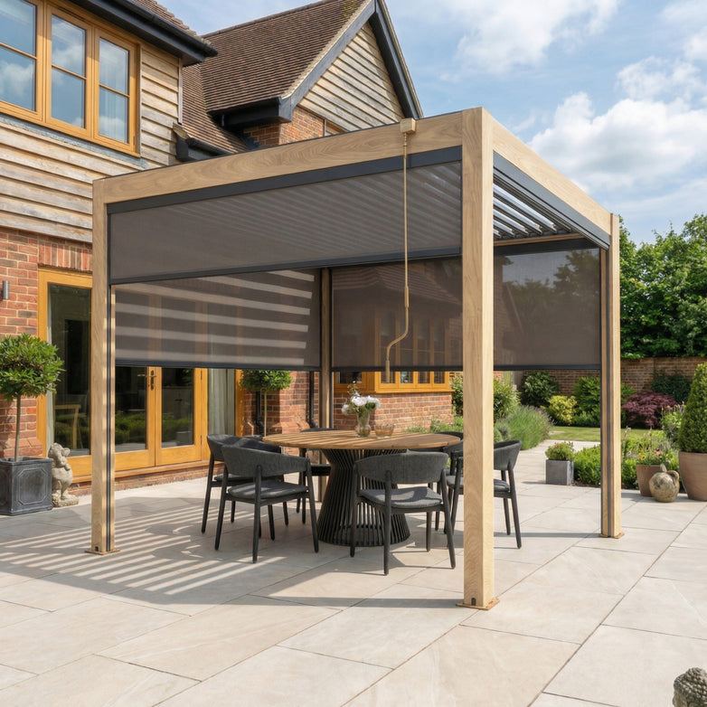 Modern patio featuring a PergoSTET Plus 3m x 3m Square Pergola with 3 manual side blinds and LED lighting in wood effect, complemented by an outdoor dining set and large potted plants on a tiled terrace.
