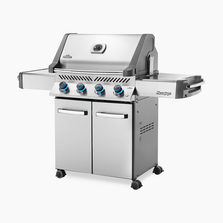 The Napoleon Prestige 500 RSIB Gas Barbecue is a stainless steel propane grill featuring four control knobs, two side trays, and a storage cabinet below. It also includes infrared side and rear burners for versatile cooking options.