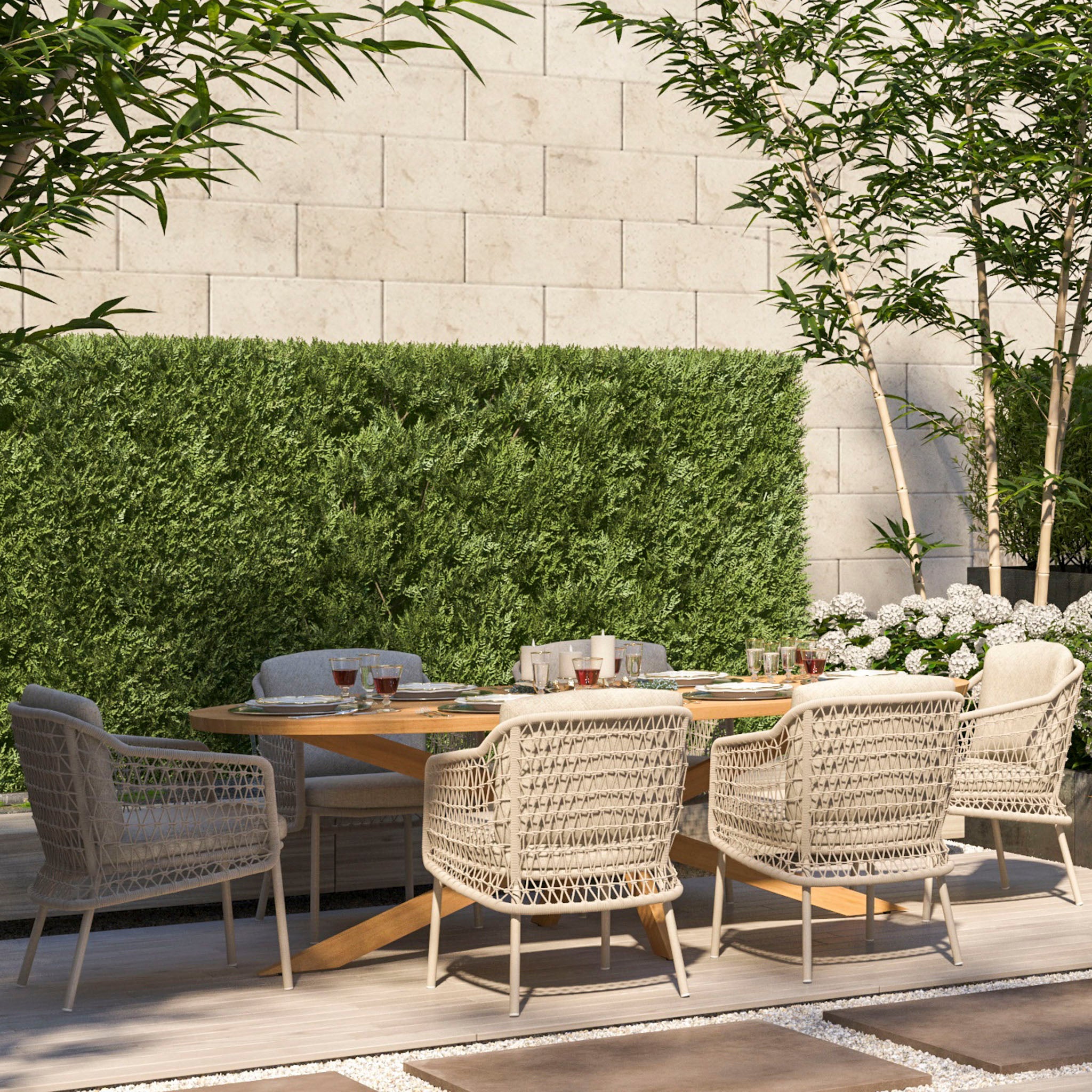 Outdoor dining area featuring the Puccini 6 Seat Oval Dining Set in Latte, complemented by a hedge backdrop, and surrounded by potted plants and stone tiles.