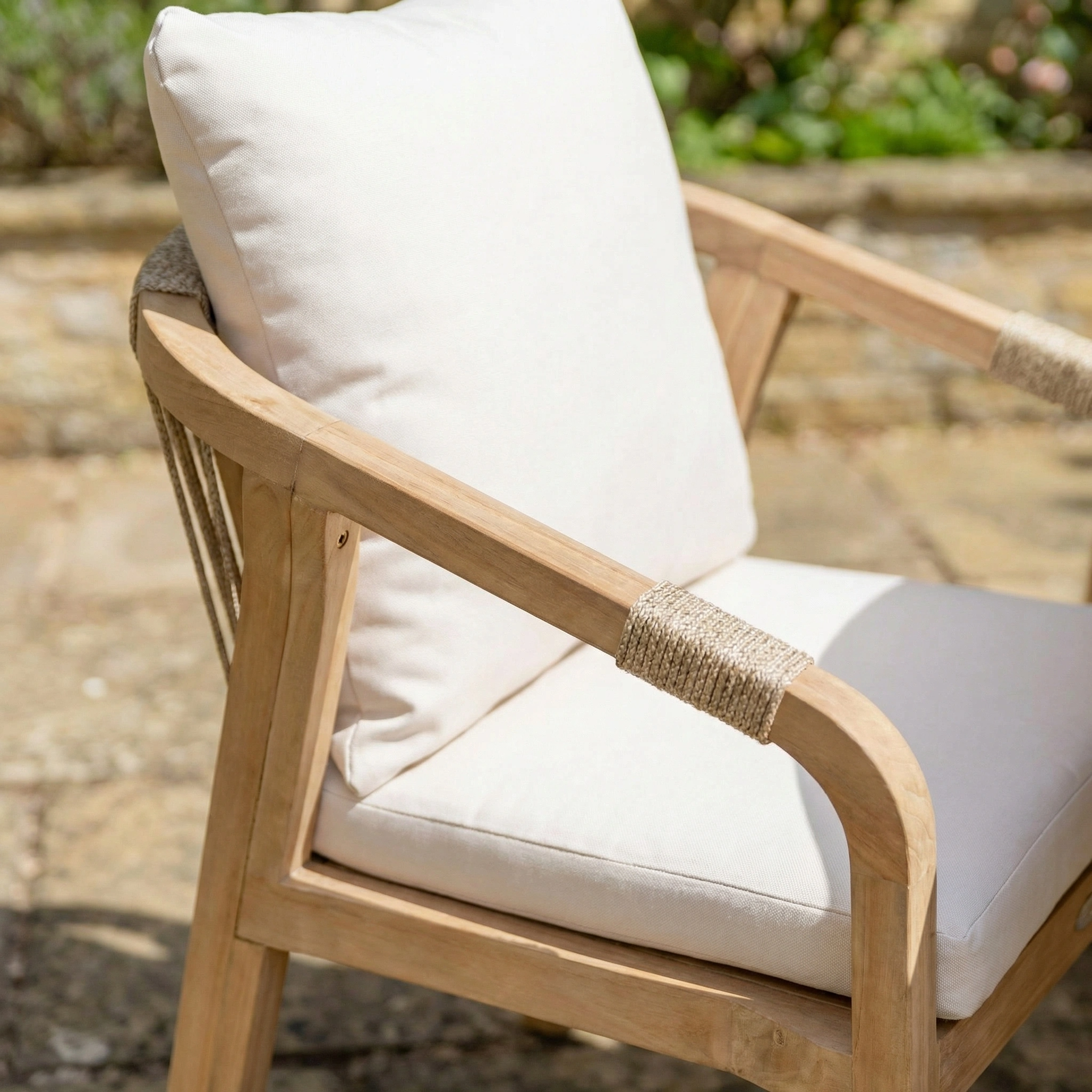 The Quay Corner Dining Set with Armchair in Linen features acacia wood, beige cushions, and rope-wrapped armrests—ideal for upgrading your stone patio outdoor furniture setup.