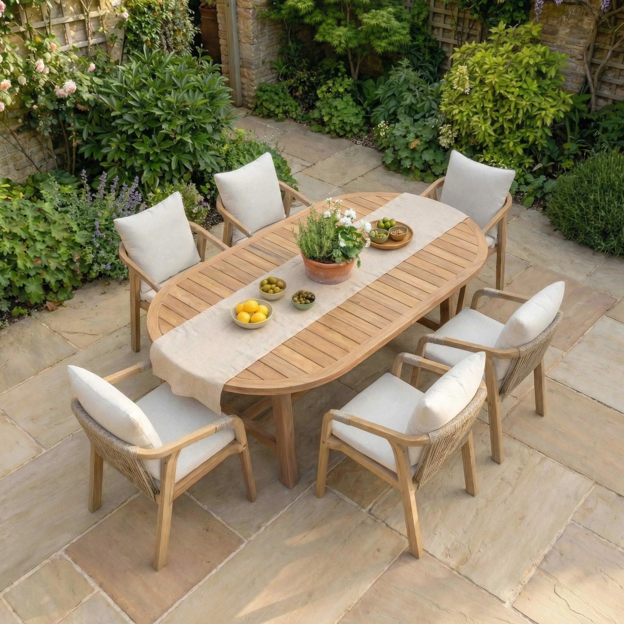 The Quay 6 Seat Oval Dining Set in Linen features acacia garden furniture with a wooden oval table and chairs, complemented by white linen cushions—ideal for adding elegance to your outdoor dining experience.