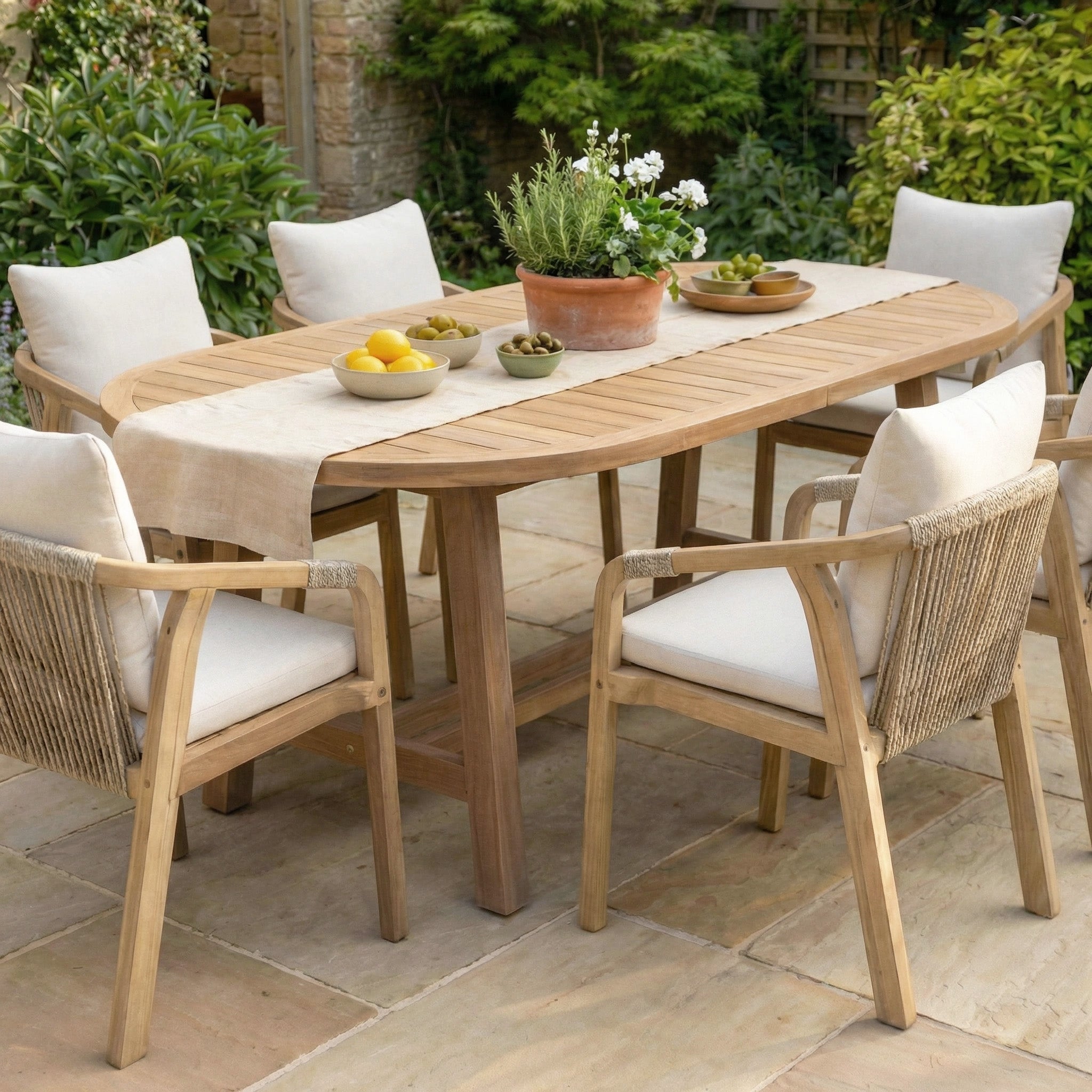 The Quay 6 Seat Oval Dining Set in Linen includes a wooden outdoor table and six cushioned chairs—ideal acacia garden furniture for stylish alfresco dining on your patio.