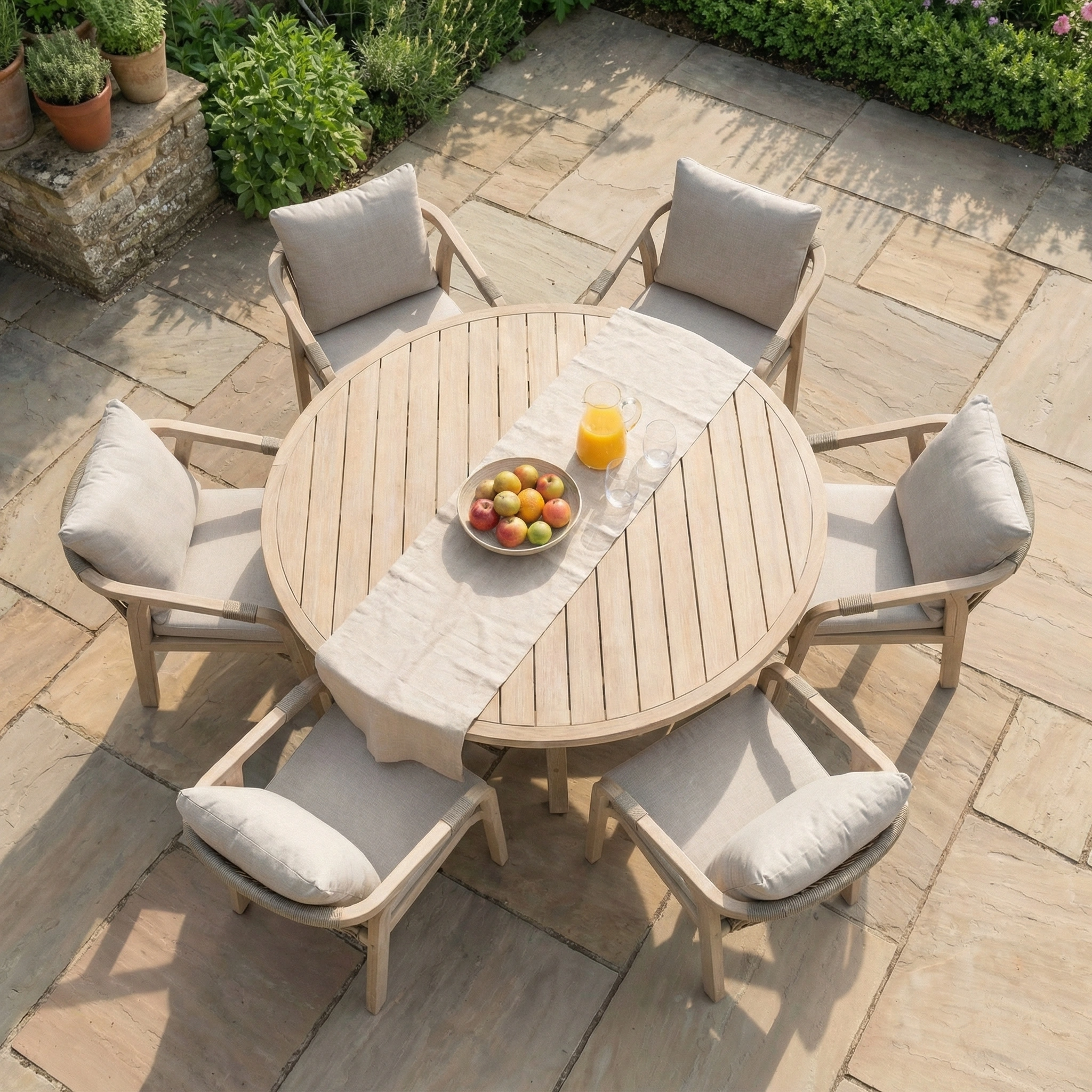 The Quay 6 Seat Round Dining Set in Mocha includes a round wooden table and eucalyptus chairs with cushions, making it an ideal choice for stylish outdoor dining.