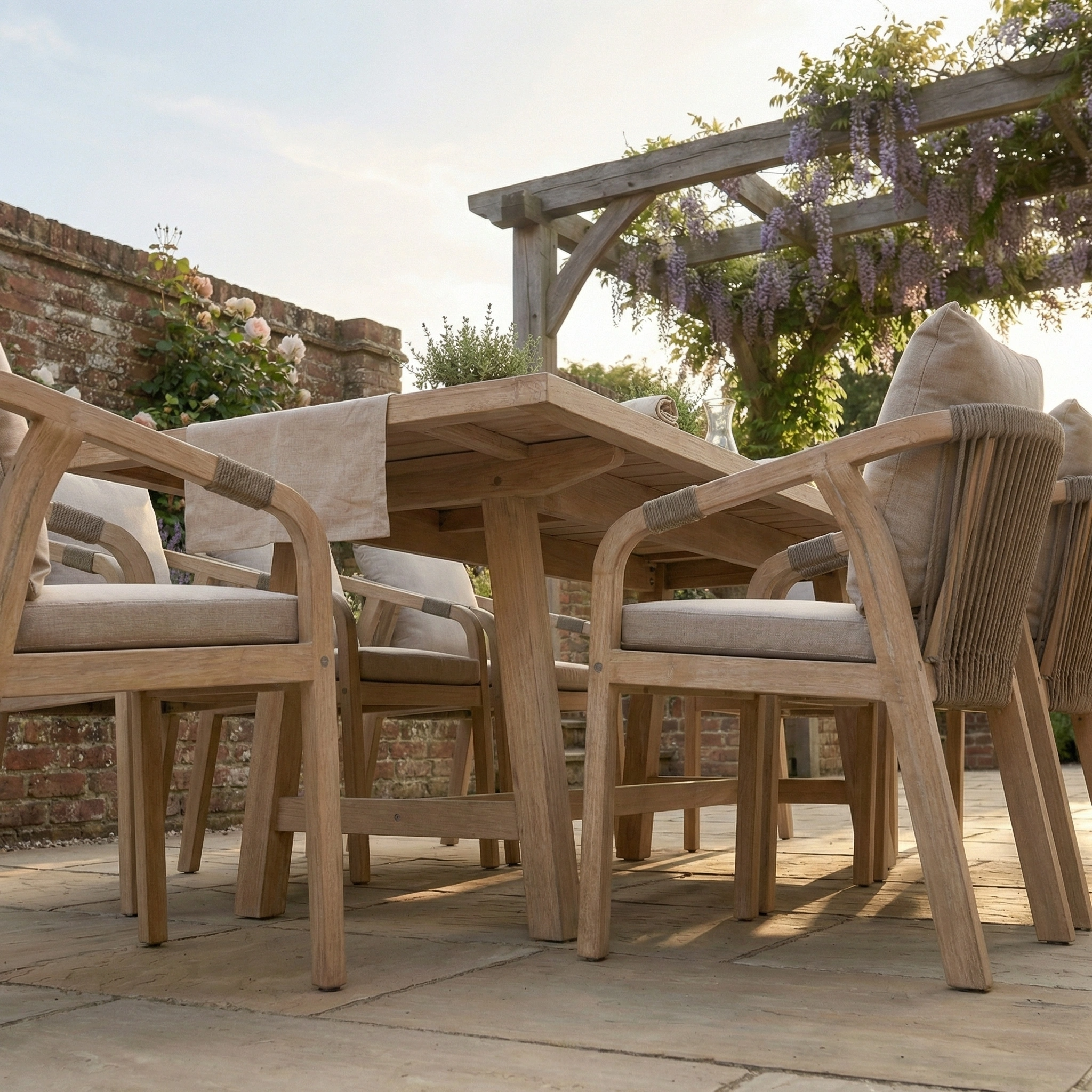 The Quay 8 Seat Rectangular Dining Set in Mocha, with upholstered chairs, is arranged under a wisteria-draped pergola for elegant alfresco dining. Crafted from teak and eucalyptus, it offers style and comfort for outdoor gatherings.
