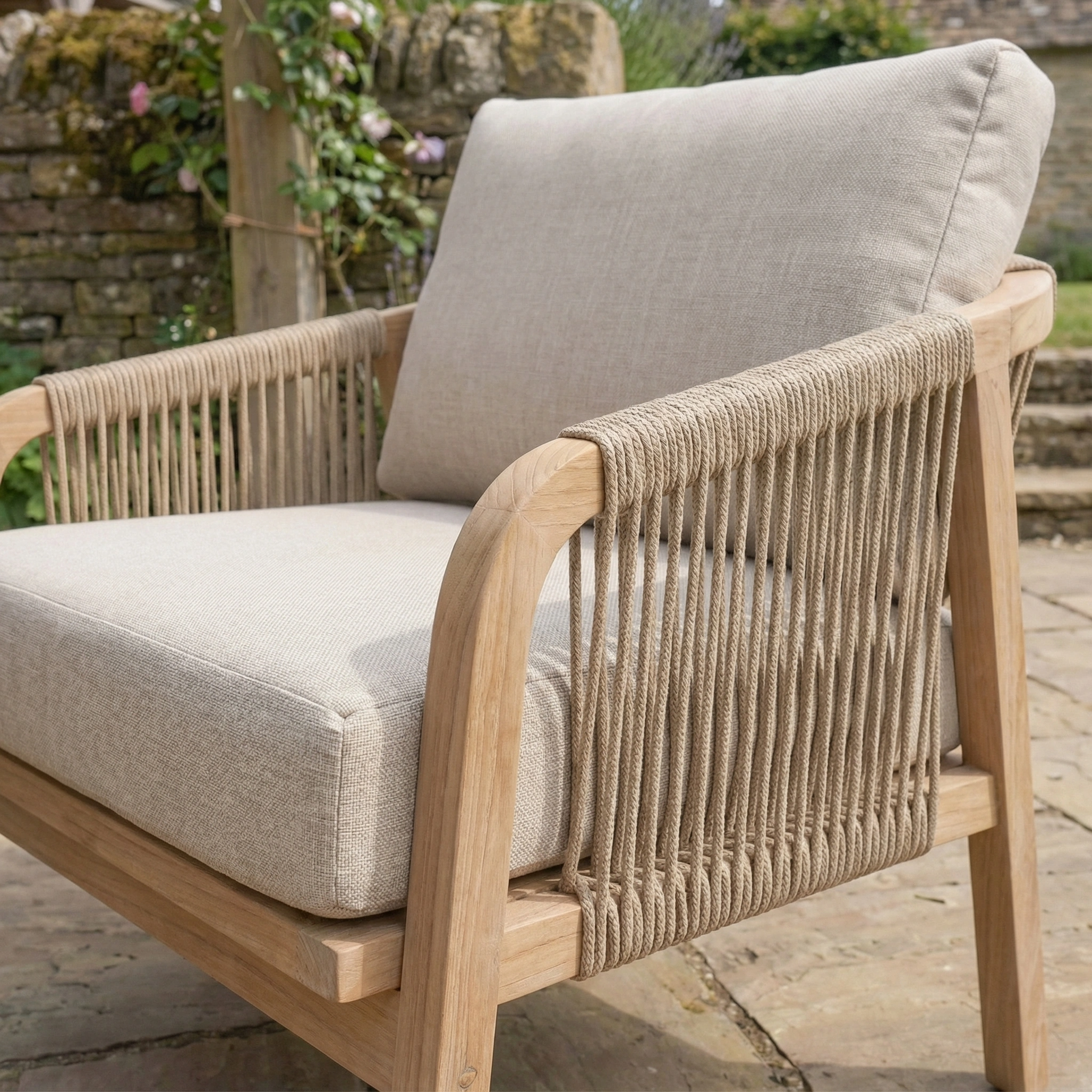 The Quay Corner Dining Set with Armchair in Mocha features rope sides, a sturdy eucalyptus wood frame, and water-resistant cushions—perfect for outdoor patios with a lush garden backdrop.