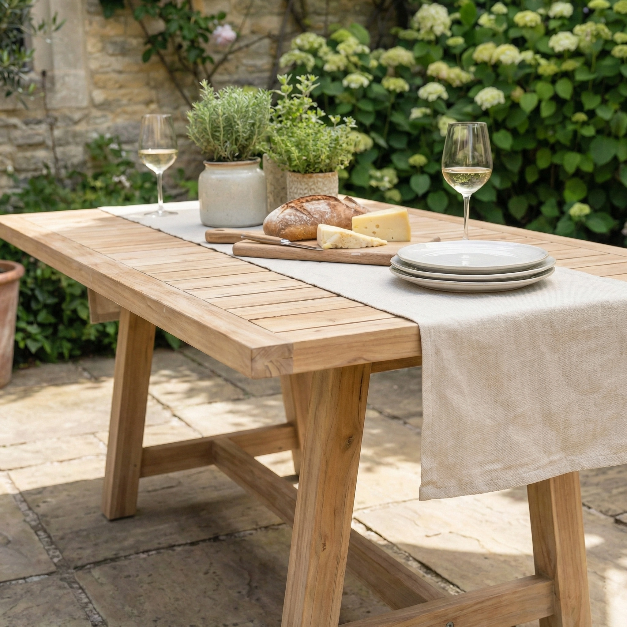 The Quay Corner Dining Set with Armchair in Linen is a wooden outdoor furniture set, perfect for patios, crafted from acacia wood and ideal for enjoying wine, bread, cheese, and more.
