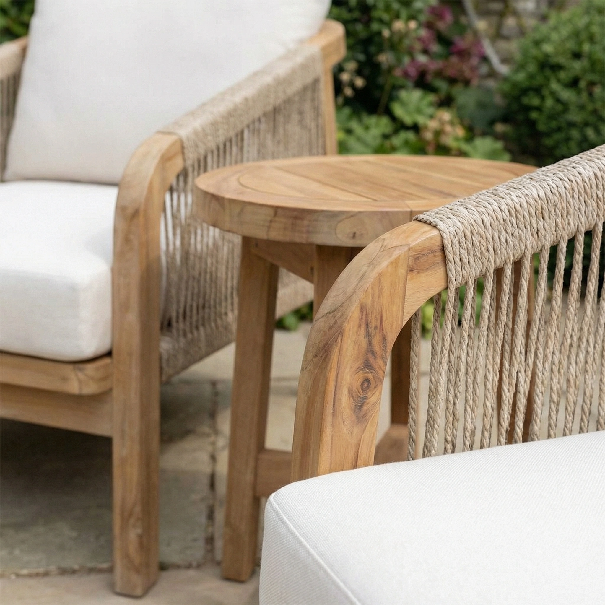 The Quay Lounge Set in Linen features wooden patio chairs with white cushions and a rope-weave back, paired with a round side table—stylish acacia wood furniture perfect for your outdoor lounging area.