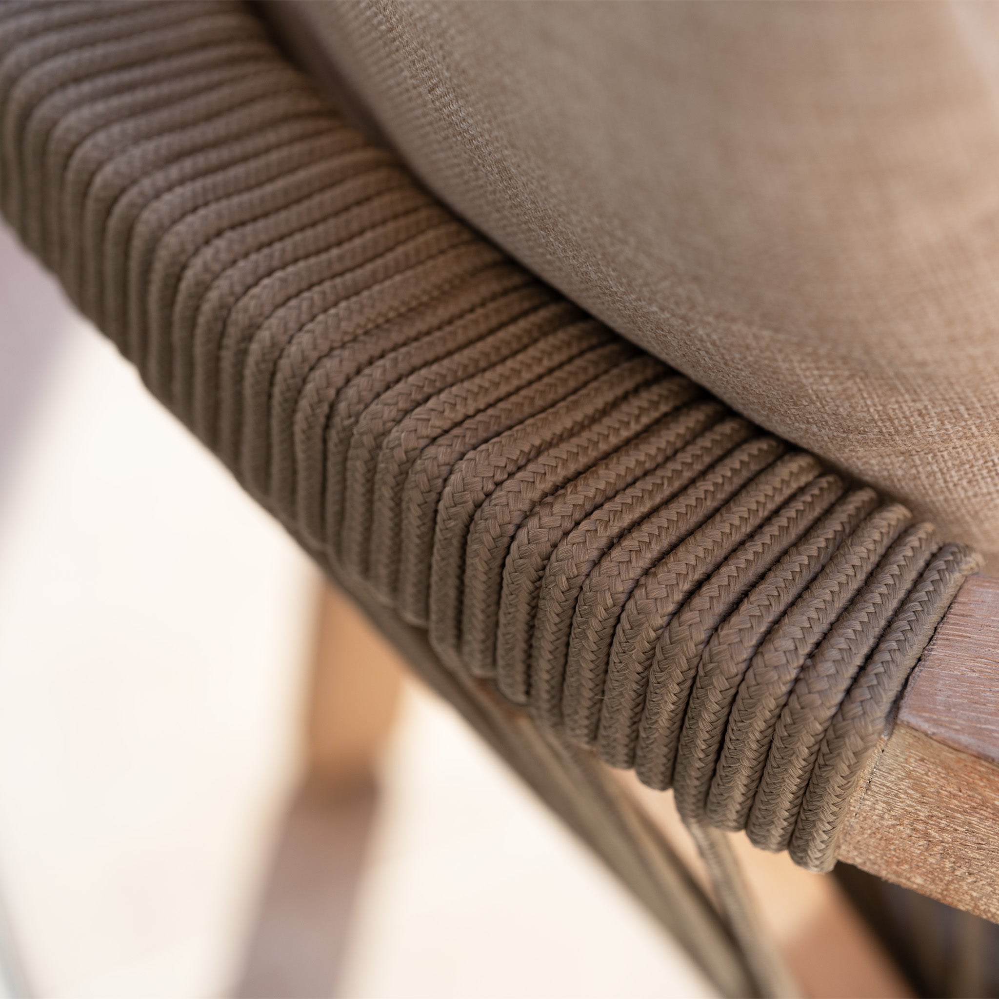 Close-up of the Quay 4 Seat Round Dining Set in Mocha, showcasing a chair with tightly woven brown rope detail, a beige cushion, and an elegant eucalyptus wood frame.