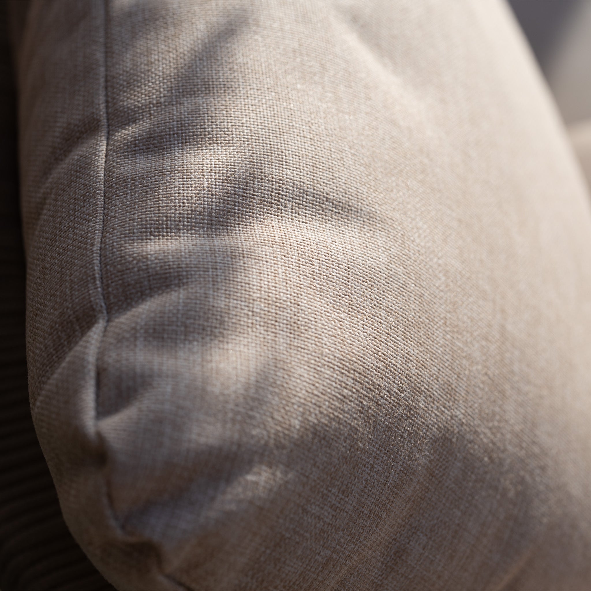 Close-up of a beige fabric cushion on the Quay 4 Seat Round Dining Set in Mocha, highlighting its texture and detailed stitching in natural light.