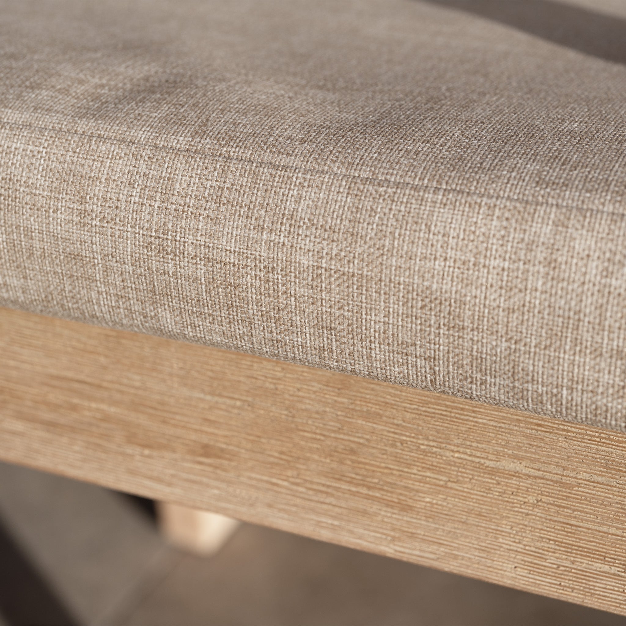 Close-up of the Quay Corner Sofa Dining Set in Mocha, featuring a beige upholstered seat cushion on a light wood bench with a rope-weave backrest, sunlight casting soft shadows.