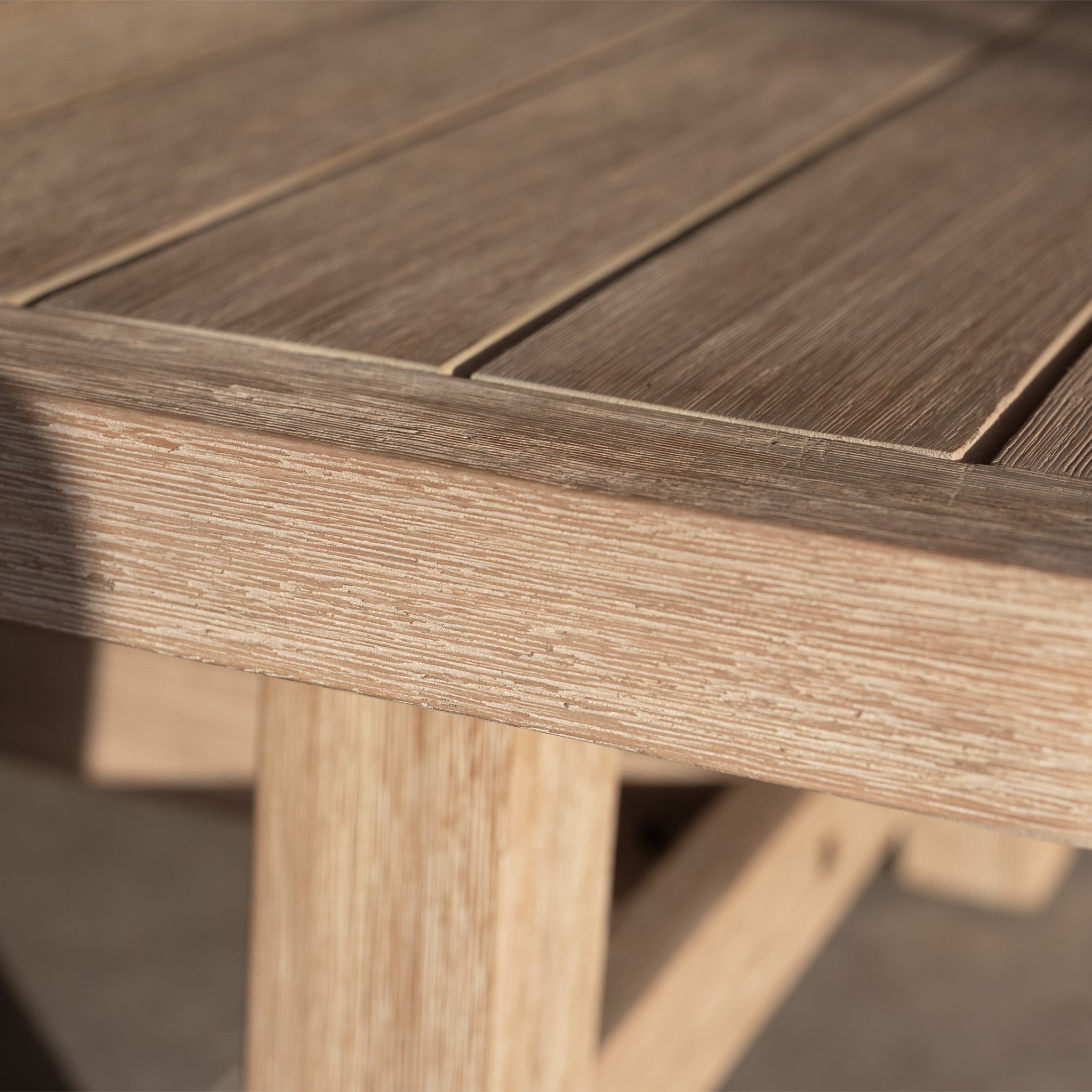 Close-up of the Quay Corner Sofa Dining Set in Mocha, featuring a wooden table corner with textured wood grain and a slatted tabletop design.