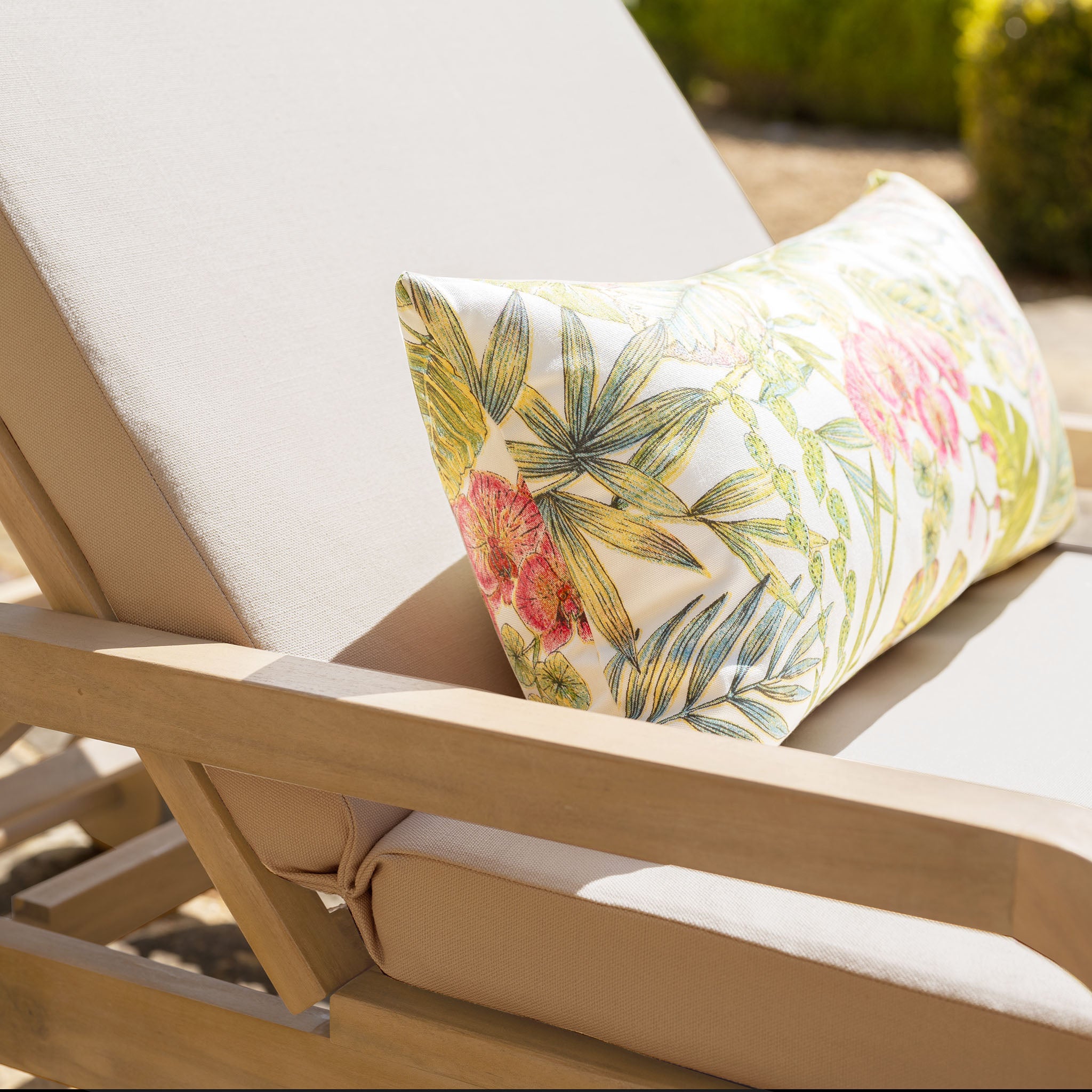 Mocha Quay Sun Lounger with a floral and leafy patterned pillow, ideal outdoor furniture for relaxing as a garden sun lounger.