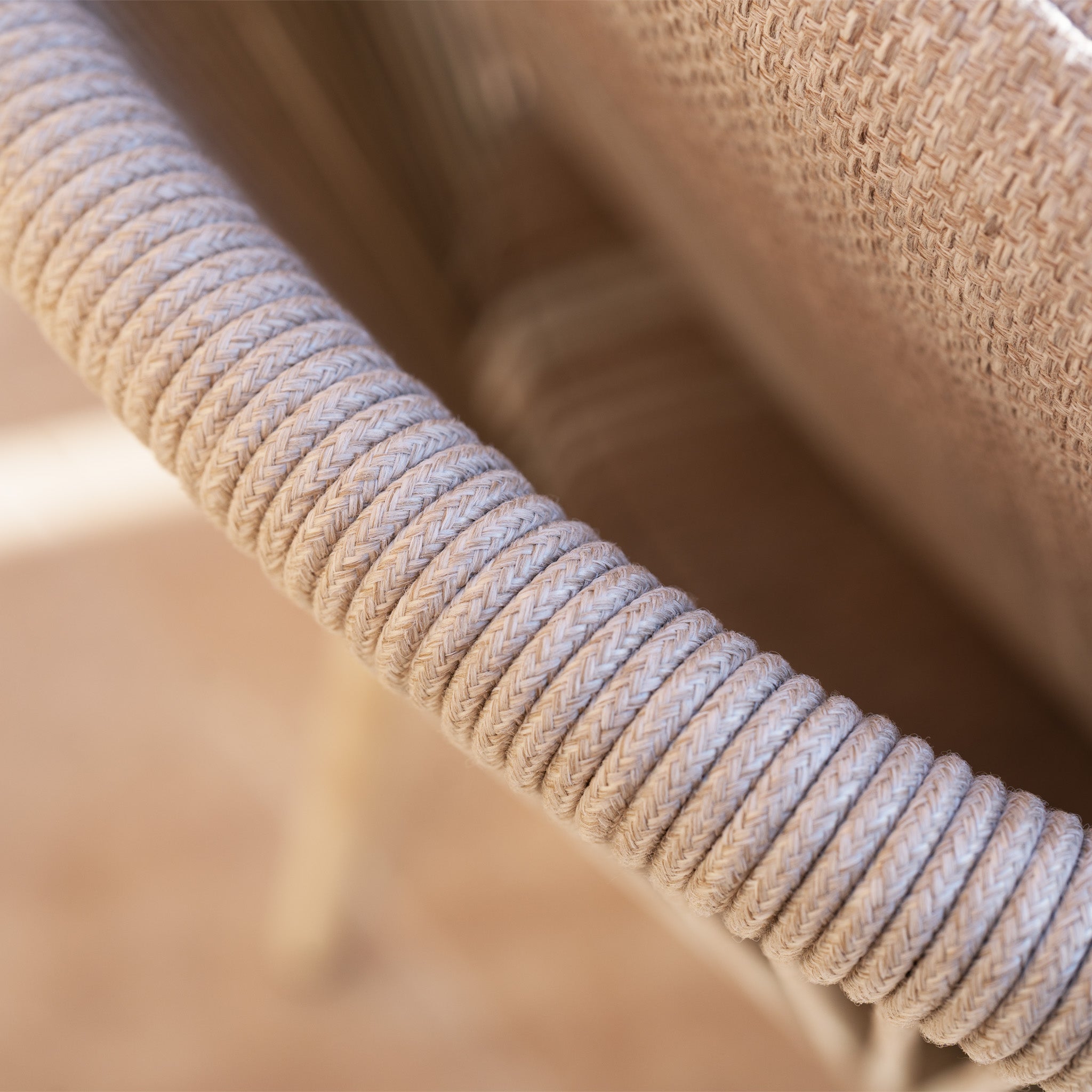 Close-up of a beige, rope-wrapped chair armrest from the Ravona 6 Seat Rope Extending Dining Set (162-222cm) in Latte, showcasing its woven texture and durable aluminium frame—ideal for stylish outdoor dining.