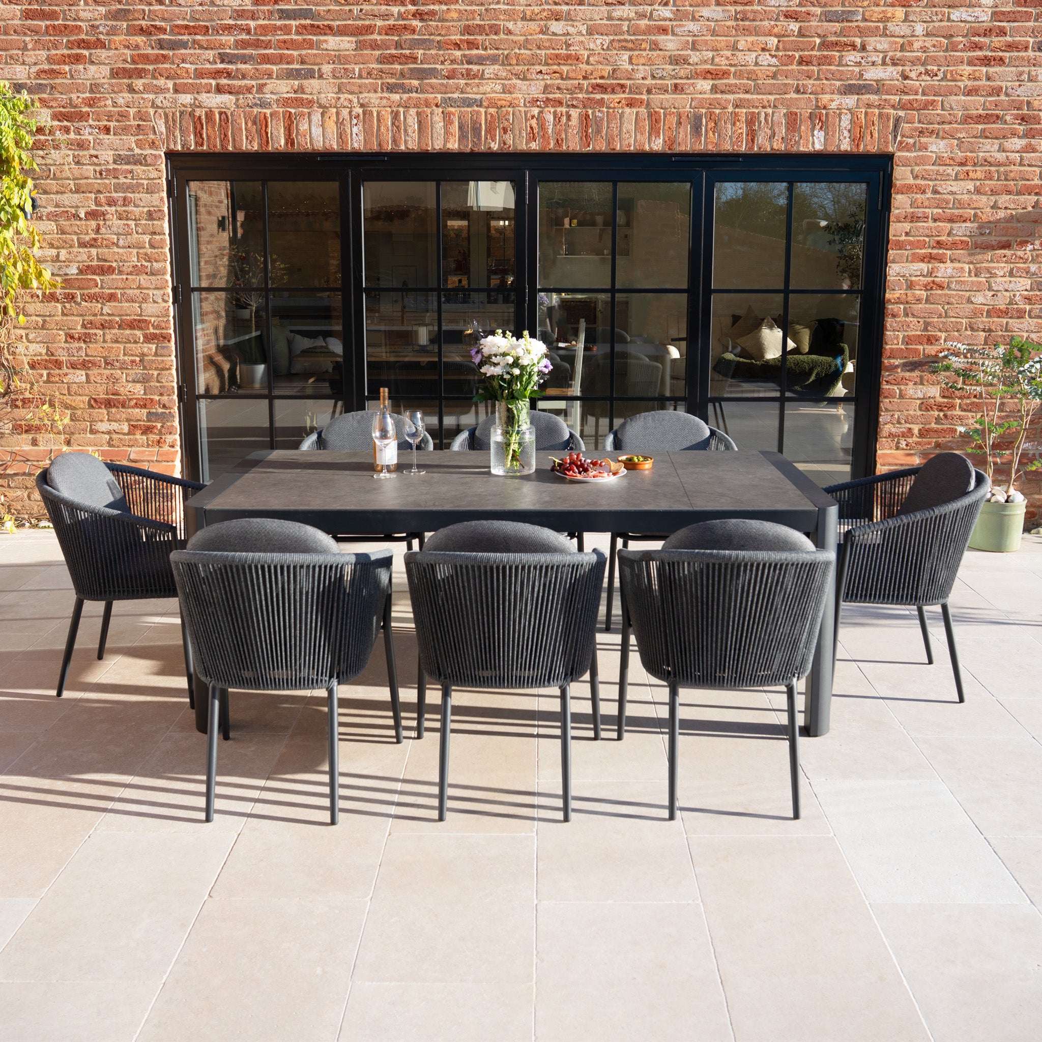 The Ravona 8 Seat Rope Extending Dining Set (162-222cm) in Charcoal includes an extendable table and eight chairs, perfect for garden dining on the patio.