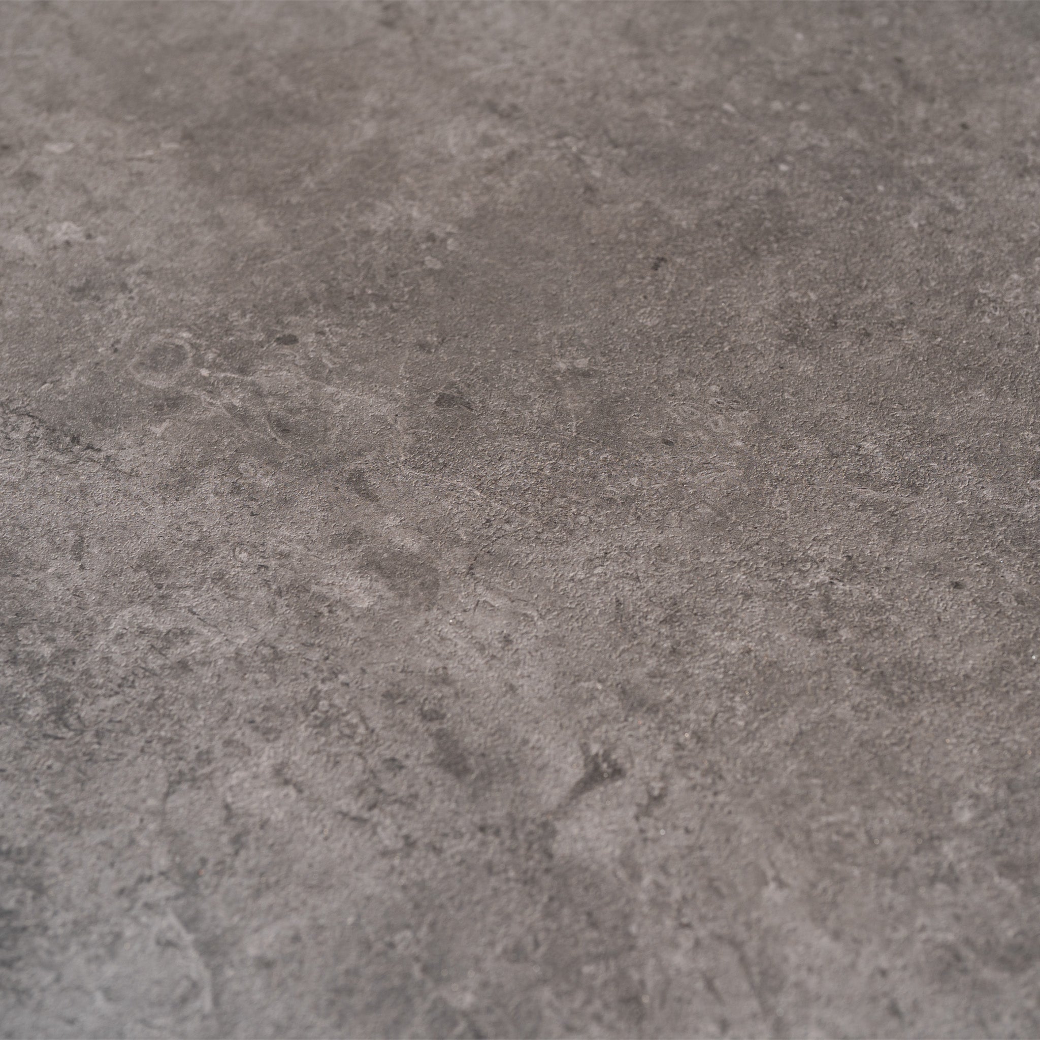 Close-up of a textured gray concrete surface with subtle patterns, evoking the rugged charm and style of the Ravona 8 Seat Rope Extending Dining Set (207-277cm) in Charcoal, perfect for outdoor dining.