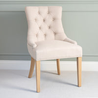 Regent Chair Set of 2 in Ivory featuring button tufting and wooden legs, styled against a light green wall for a modern look.
