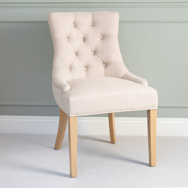Regent Chair Set of 2 in Ivory featuring button tufting and wooden legs, styled against a light green wall for a modern look.
