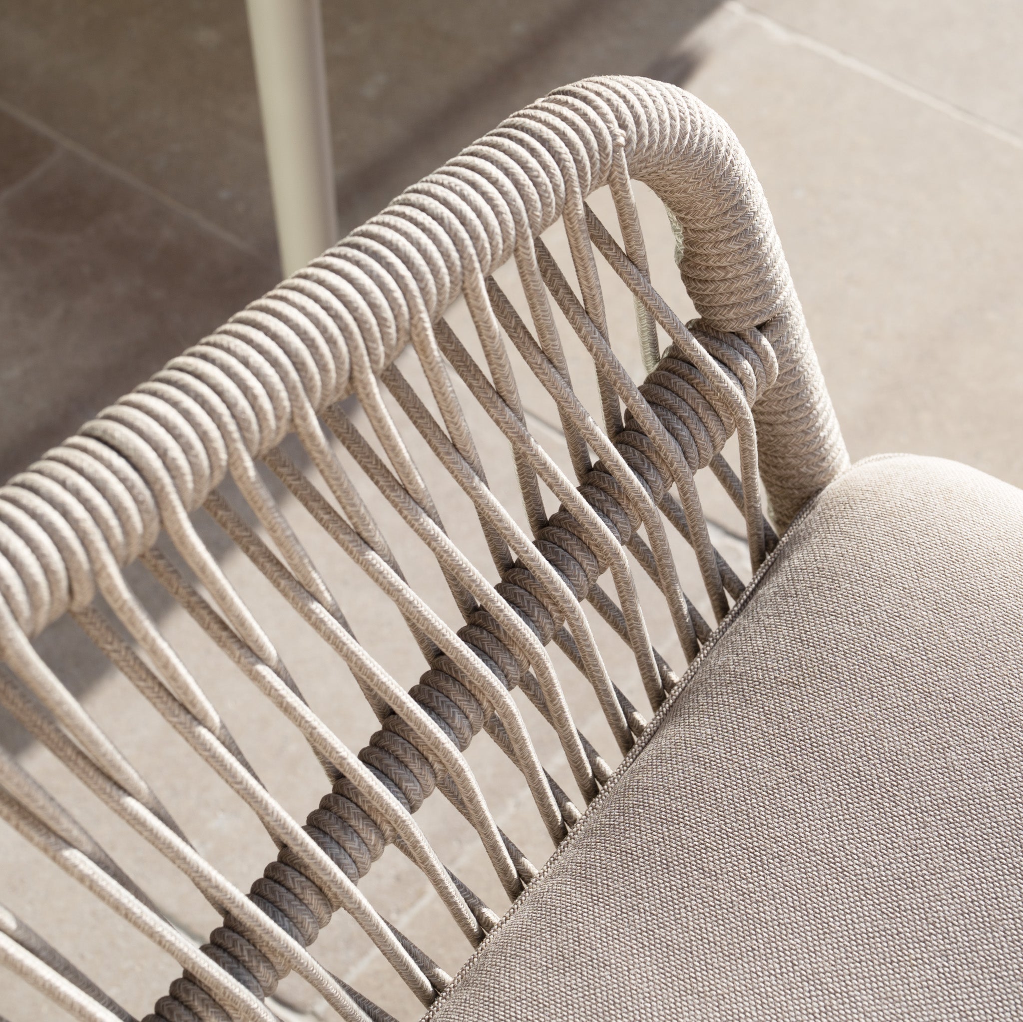 Close-up of the Rhea 2 Seat Sofa Set in Latte, featuring a beige woven rope design, soft cushions, and sturdy aluminium accents, placed on a stone floor.