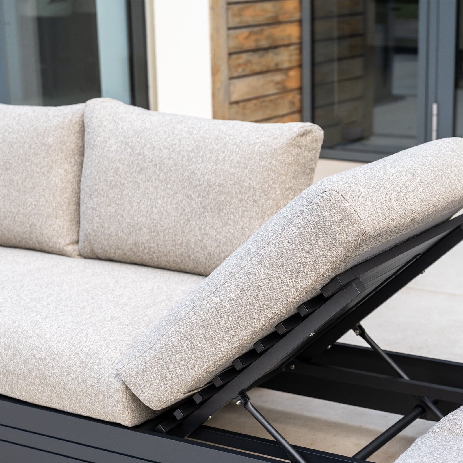 Close-up of the Savona Luxury Outdoor Large Corner Sofa Set with Altura Rising Table in Truffle, featuring light gray cushions, adjustable backrest, and a sleek modern design.