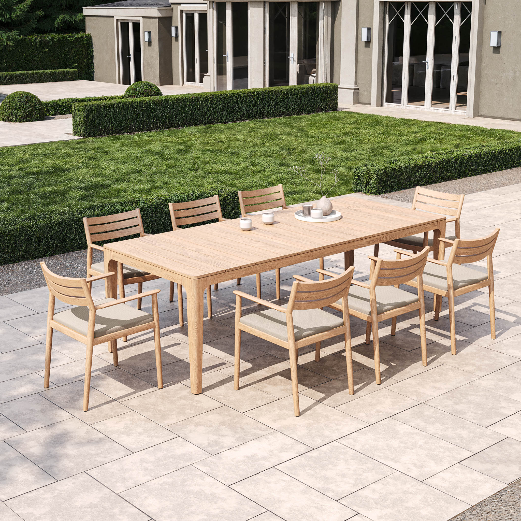 Enhance your outdoor area with the Siena 8 Seat Rope Dining Set, featuring a teak table in fawn and eight matching chairs on a tiled patio beside trimmed hedges.